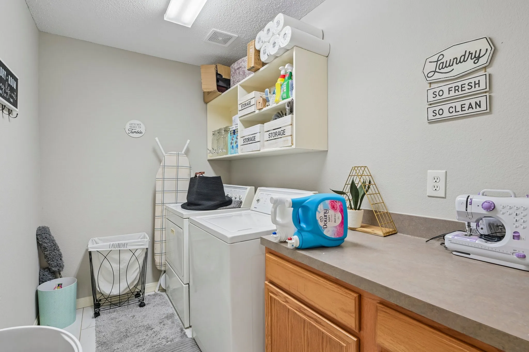 Utility room featuring light-colored walls, overhead lighting, and built-in shelving