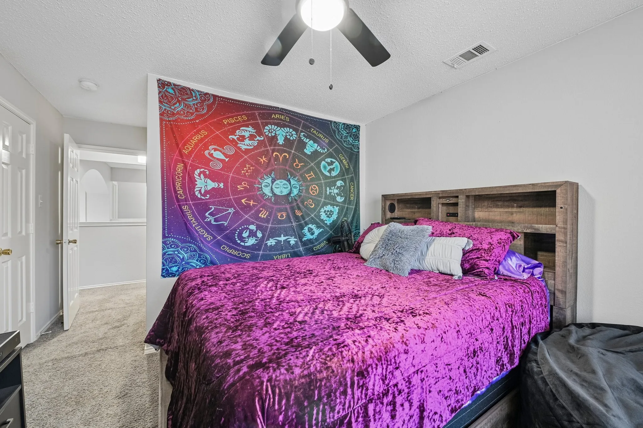Wall-to-wall carpeting, ceiling fan, and white painted walls