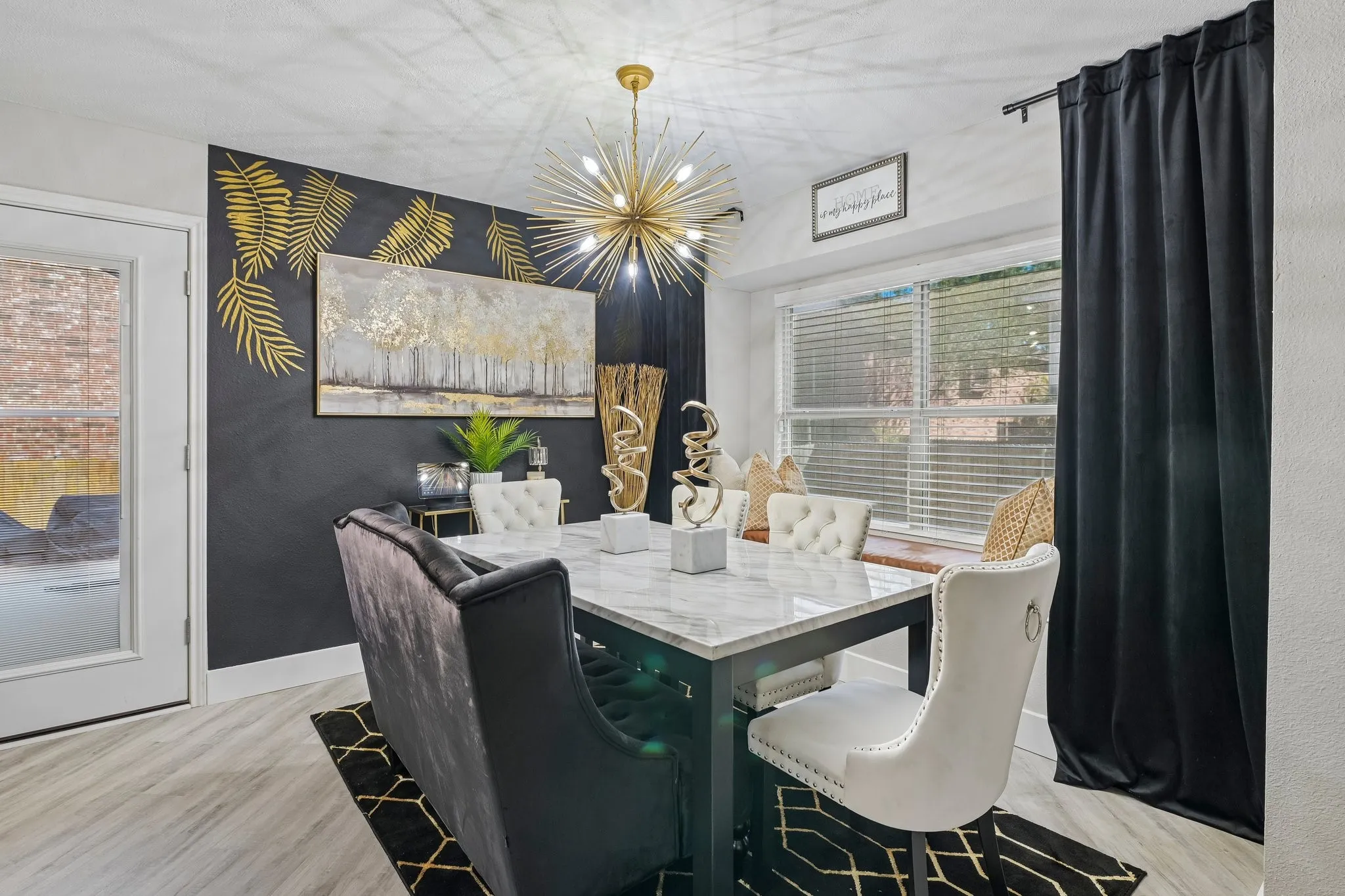 Recessed lighting and a gold-tone sputnik chandelier illuminate the dining area with wood-finish flooring