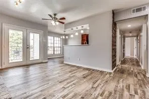 Wood-finish flooring throughout, French doors with balcony access, recessed lighting, and a ceiling fan