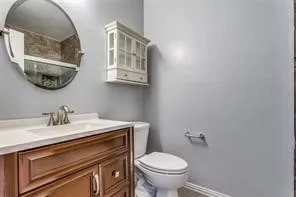 Elegant half bath featuring a wood-finish vanity with dual drawers, white quartz countertop, and chrome faucet