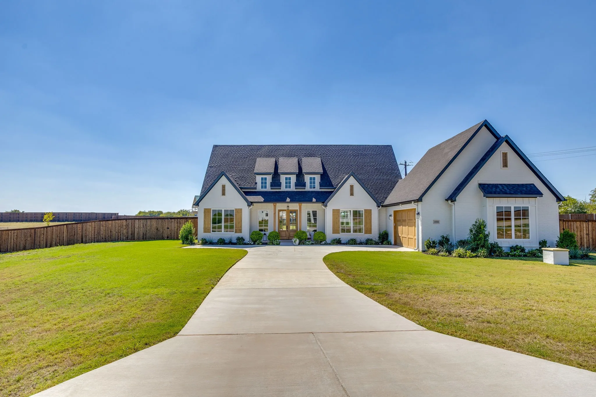 White stucco exterior with a dark roof and multiple gables