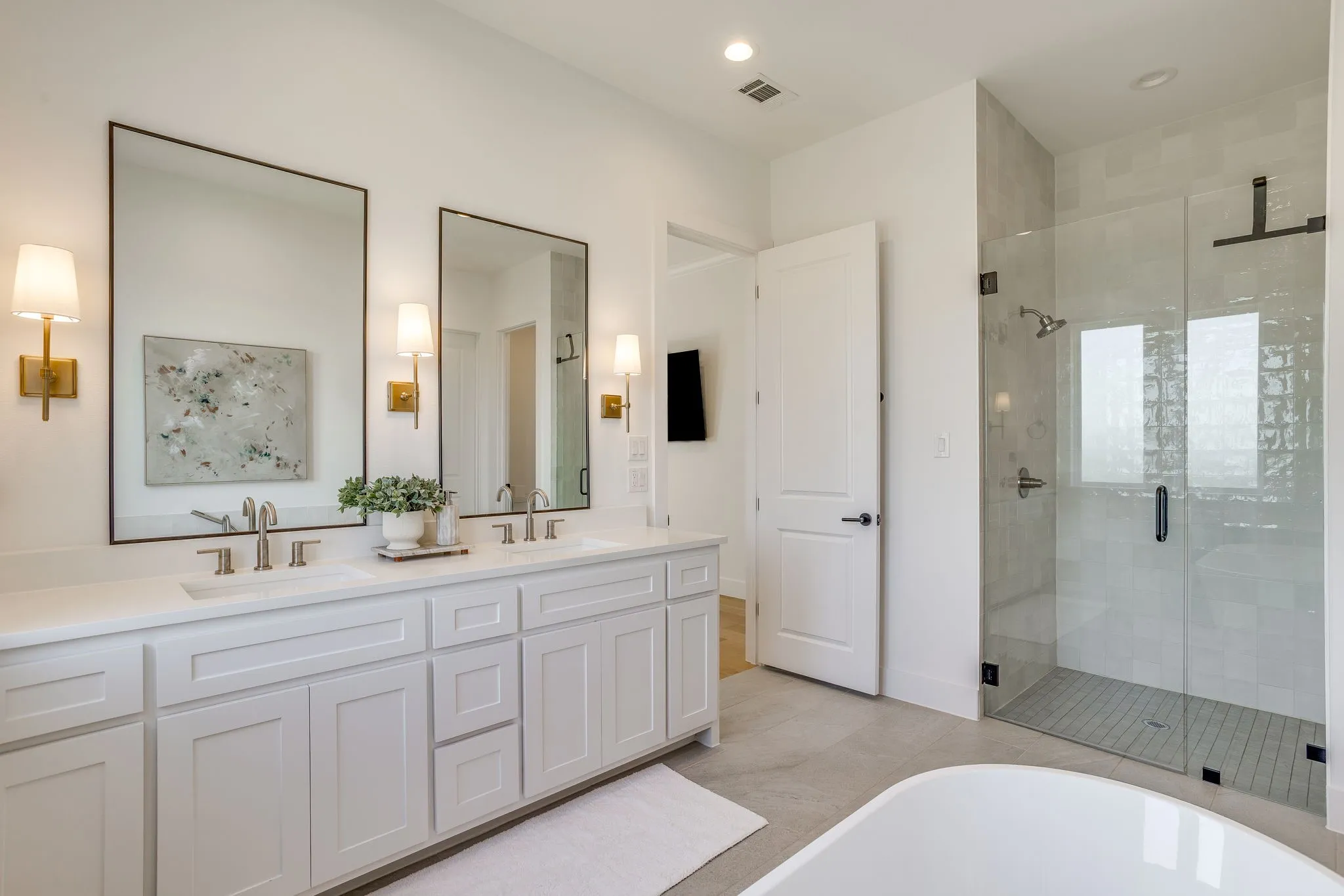 Dual vanity with white shaker-style cabinetry and a light-toned countertop