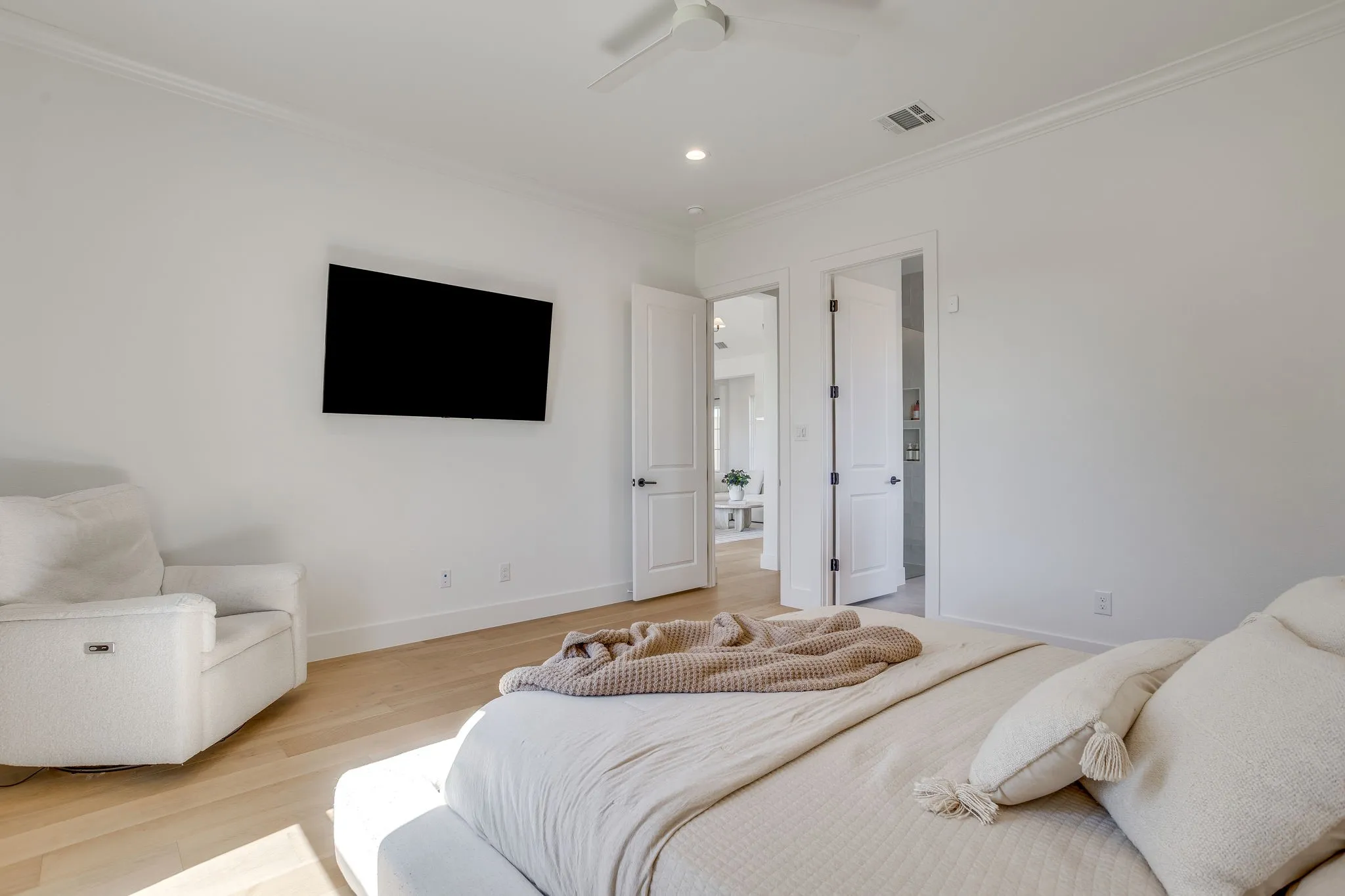 Recessed lighting, crown molding, wood-finish flooring, and white interior doors with black hardware