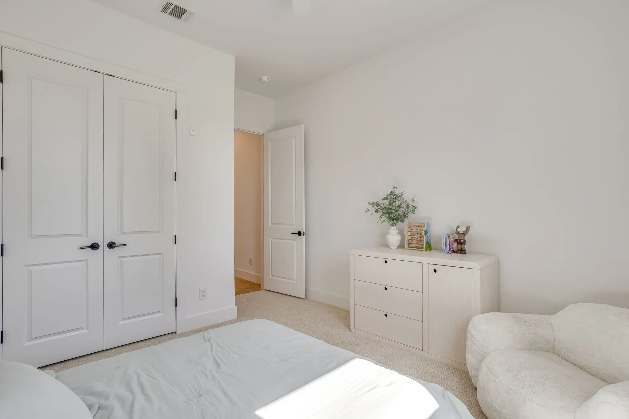 Light-toned carpeting, white walls, and white trim create a bright aesthetic
