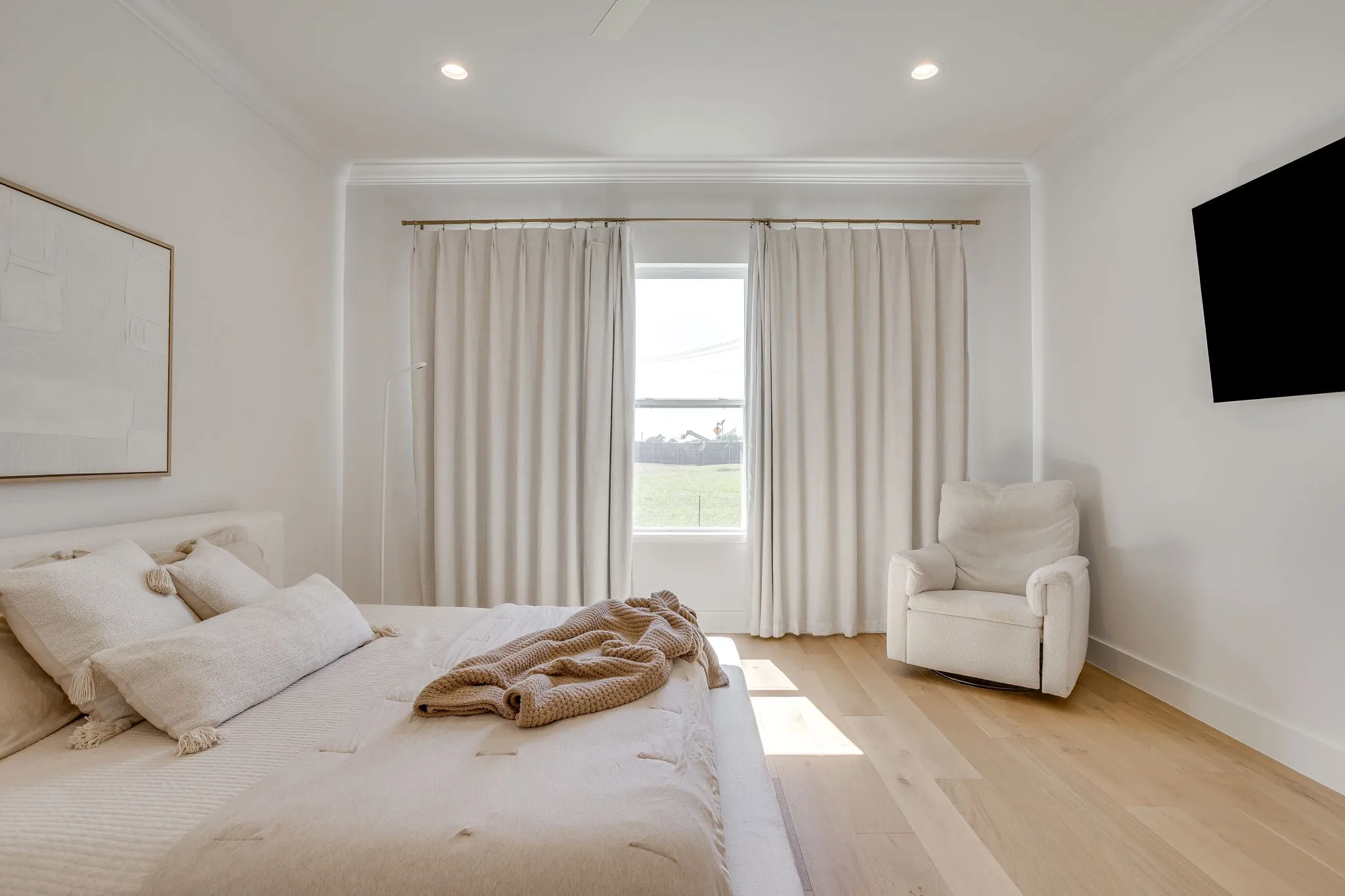 Recessed ceiling lighting, crown molding, wood-finish flooring, and a mounted display