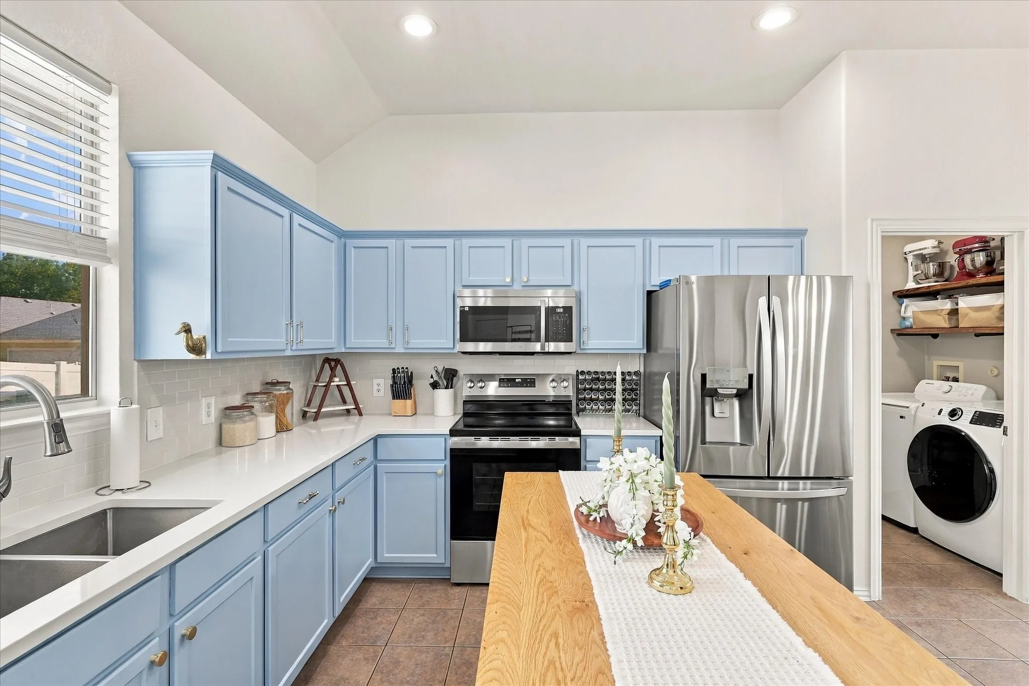 Kitchen featuring light blue cabinetry, stainless steel appliances, a double basin sink, recessed lighting, and a pantry with built-in shelving