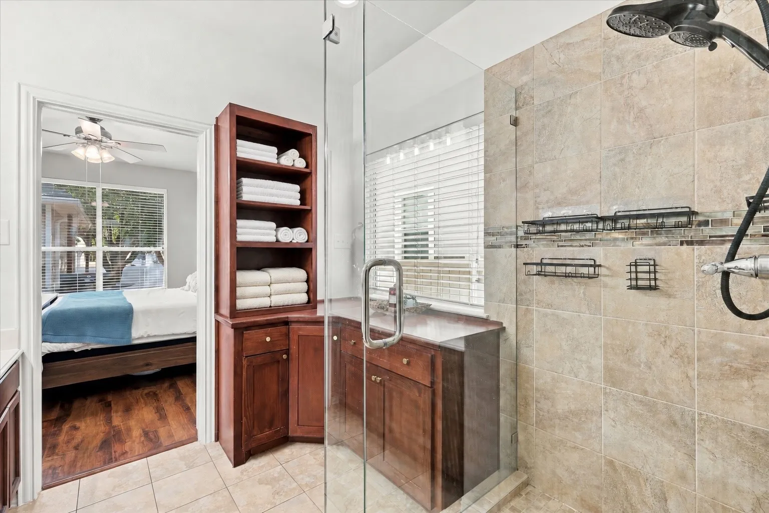 Glass-enclosed shower with stone-look tile, mosaic accent band, and dual showerheads