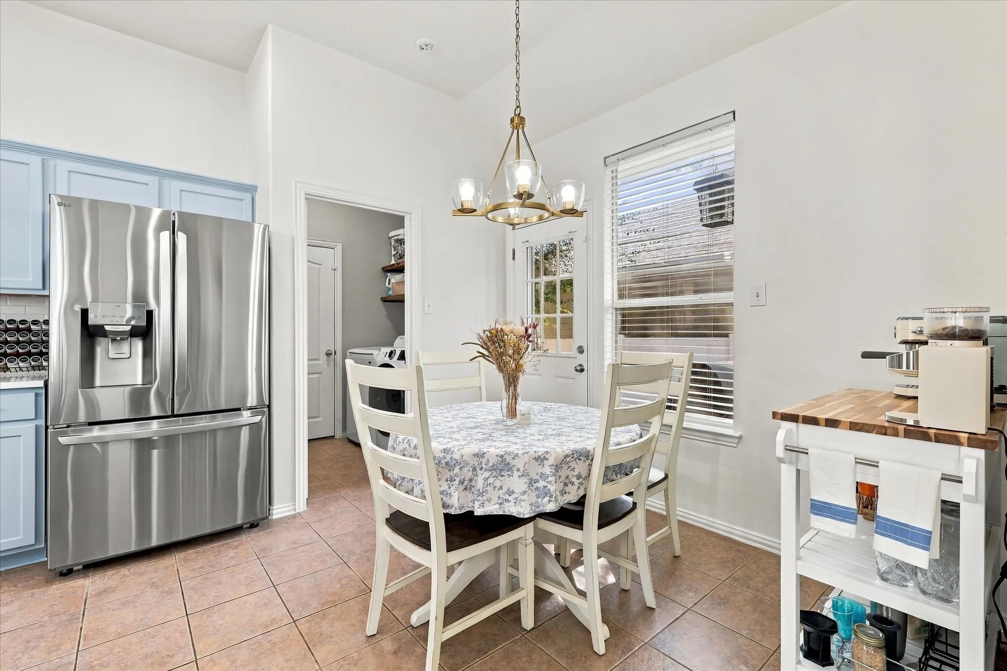 Stainless steel French door refrigerator, light blue cabinetry, tiled flooring, built-in ceiling light, and a functional pantry