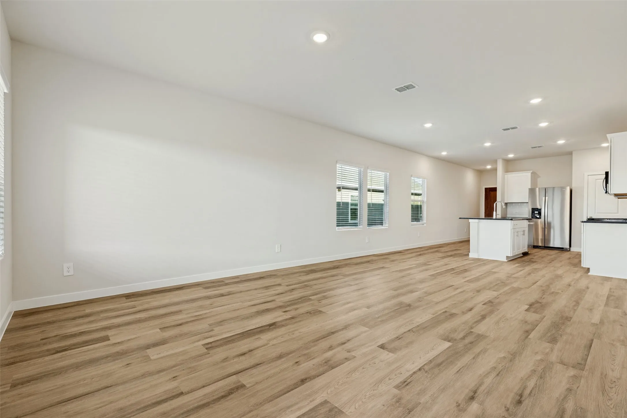 Room to Gather, Relax & Entertain! - This expansive view highlights the home's thoughtfully designed living spaces, with generous room for comfortable seating, dining, and entertaining. The kitchen's central island keeps everything connected while maintaining distinct areas for daily activities.
