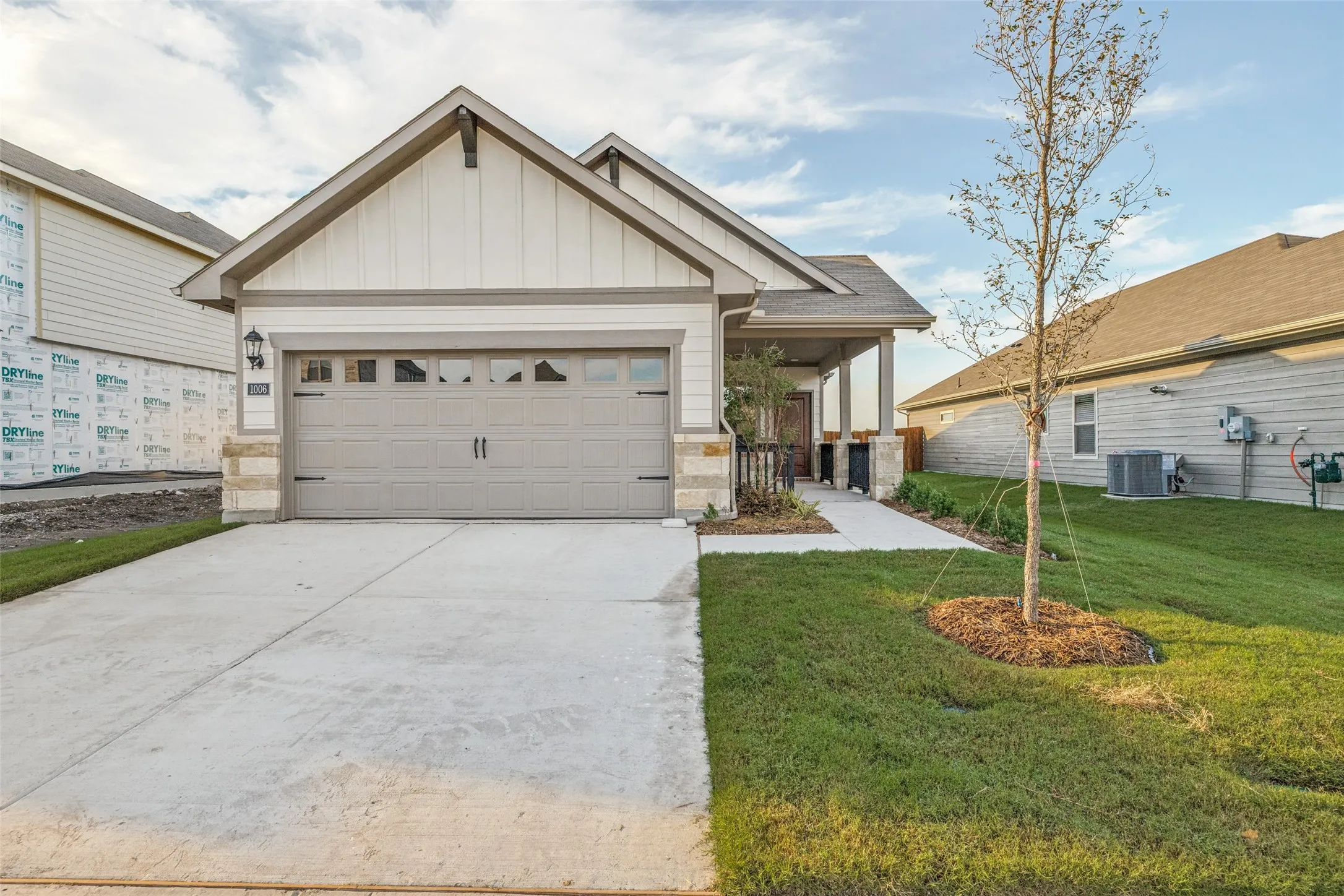 Fresh Curb Appeal & Everyday Convenience - Classic bungalow-inspired architecture, contrasting exterior trim, an attached two-car garage with Wi-Fi-enabled opener, and a spacious driveway create an inviting first impression with practical features for everyday living.