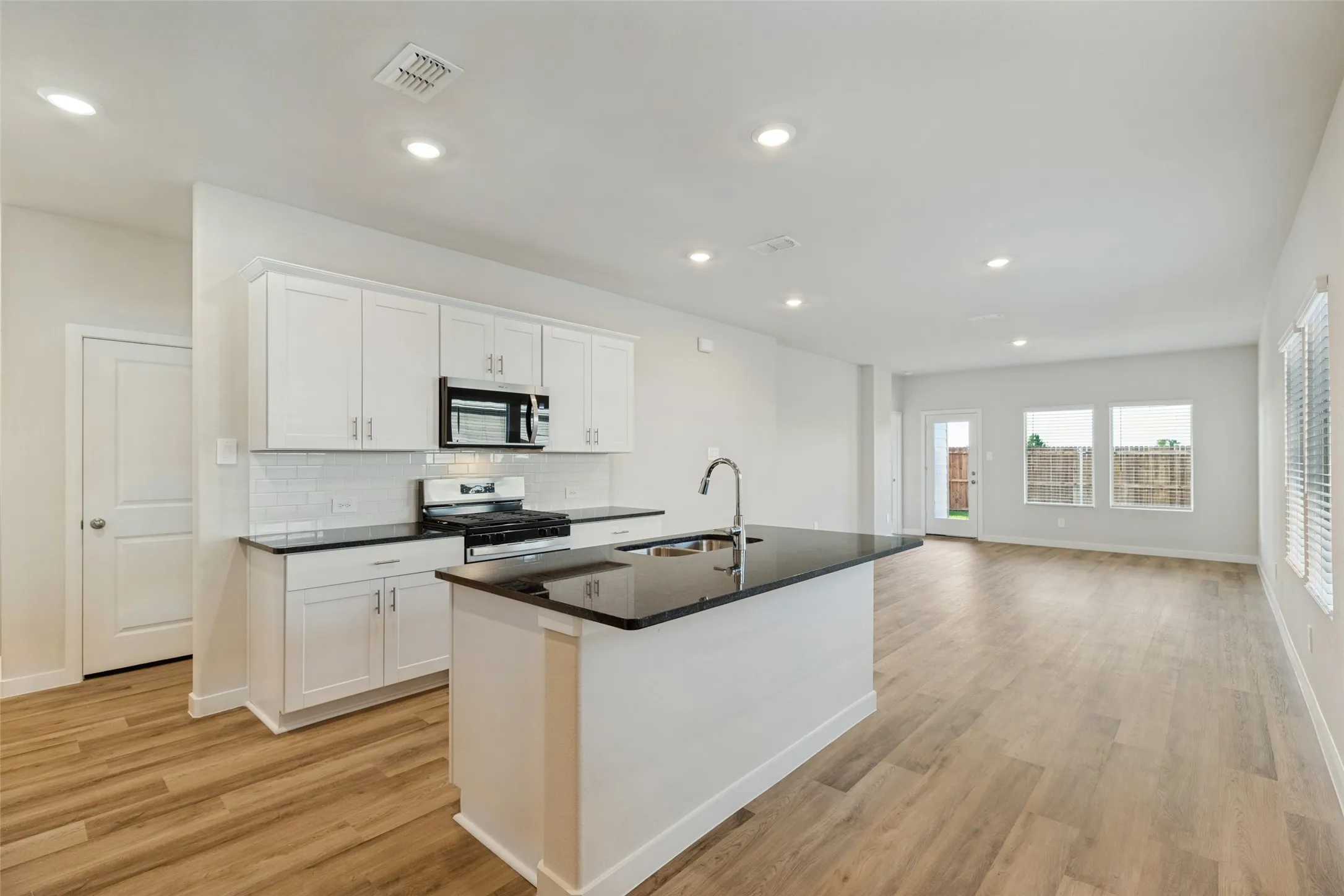 Stylish Finishes & an Open, Functional Layout! - Crisp white cabinetry contrasts beautifully with dark granite countertops, while stainless steel appliances and recessed lighting complete the modern look. The spacious island provides additional prep space and casual seating opportunities.