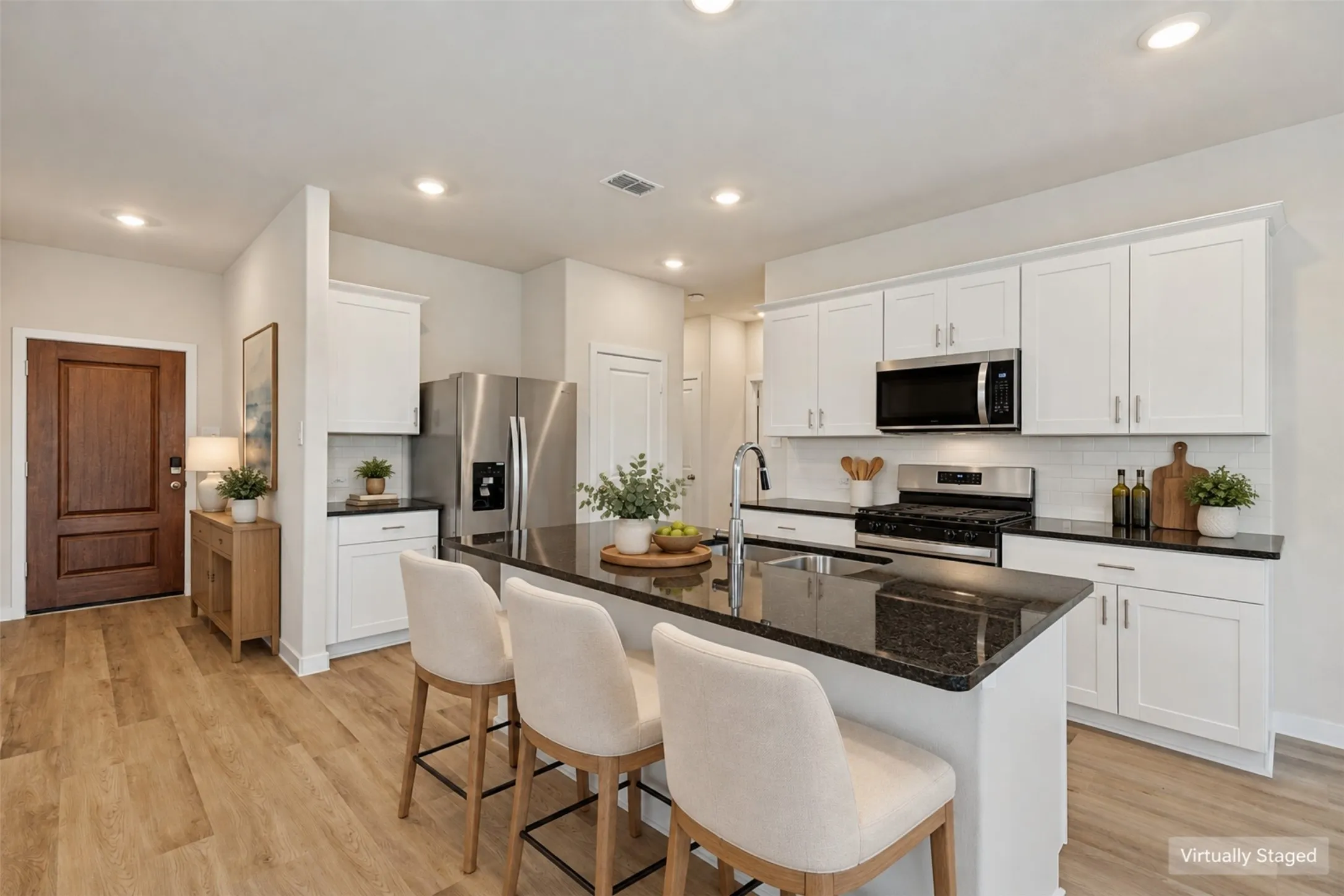 A Kitchen Designed for Real Life! - Enjoy generous counter space, abundant cabinet storage, and a central island with an undermount sink and breakfast bar. The stainless steel gas range, built-in microwave, and refrigerator make this thoughtfully arranged kitchen ready for everyday cooking and entertaining.