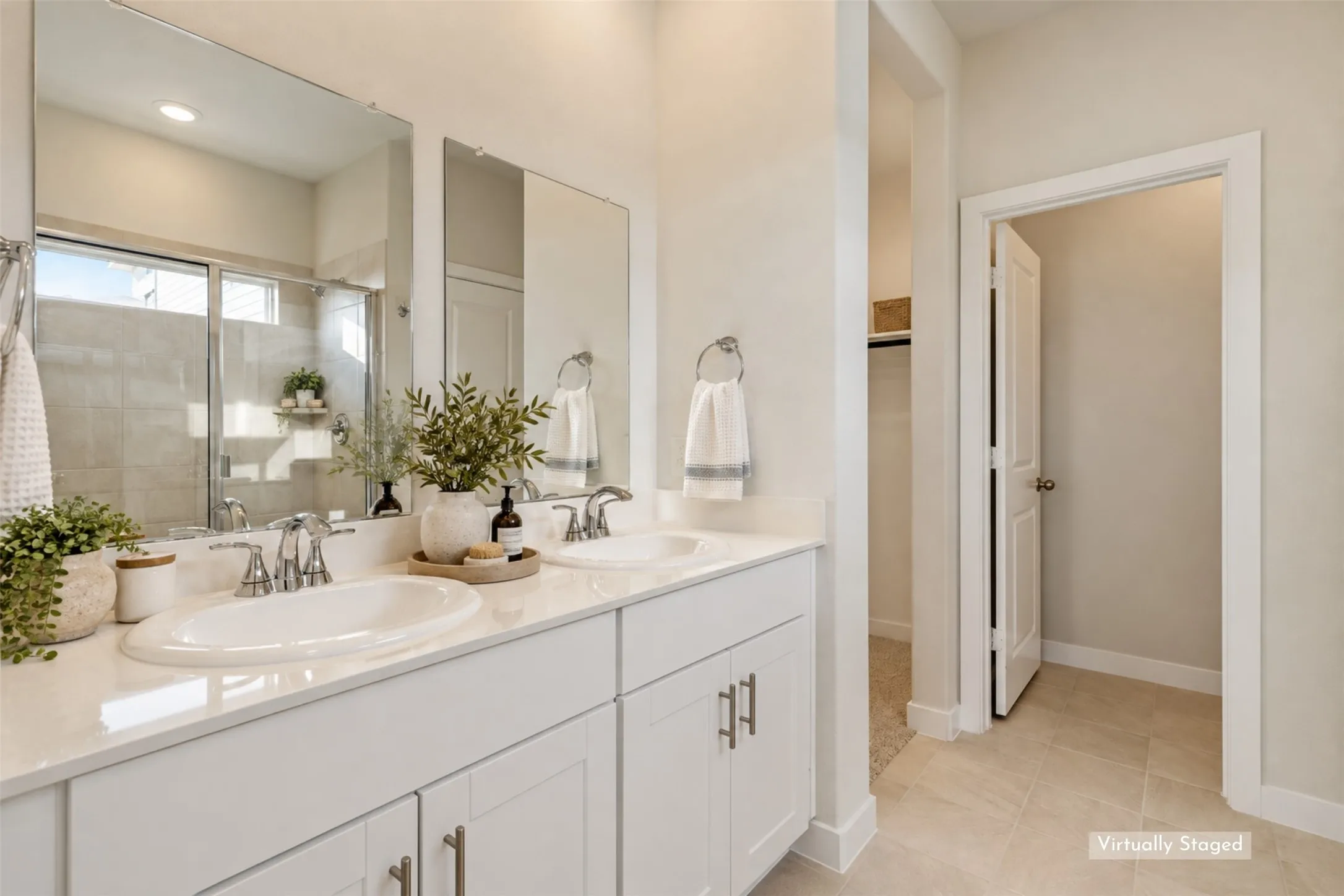 Your Personal Space to Refresh & Recharge! - The bright primary bathroom features dual sinks, white shaker-style cabinetry, sleek chrome fixtures, and generous vanity counter space. A separate glass-enclosed shower and private water closet complete this functional ensuite retreat.