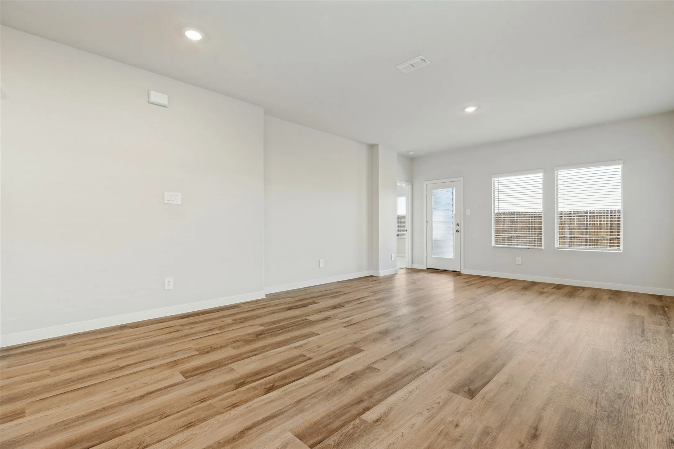 Open, Airy & Designed for Everyday Living! - The spacious family room features durable executive vinyl plank flooring, recessed lighting, and an open layout that connects effortlessly with the dining area and kitchen, making everyday living and entertaining a breeze.