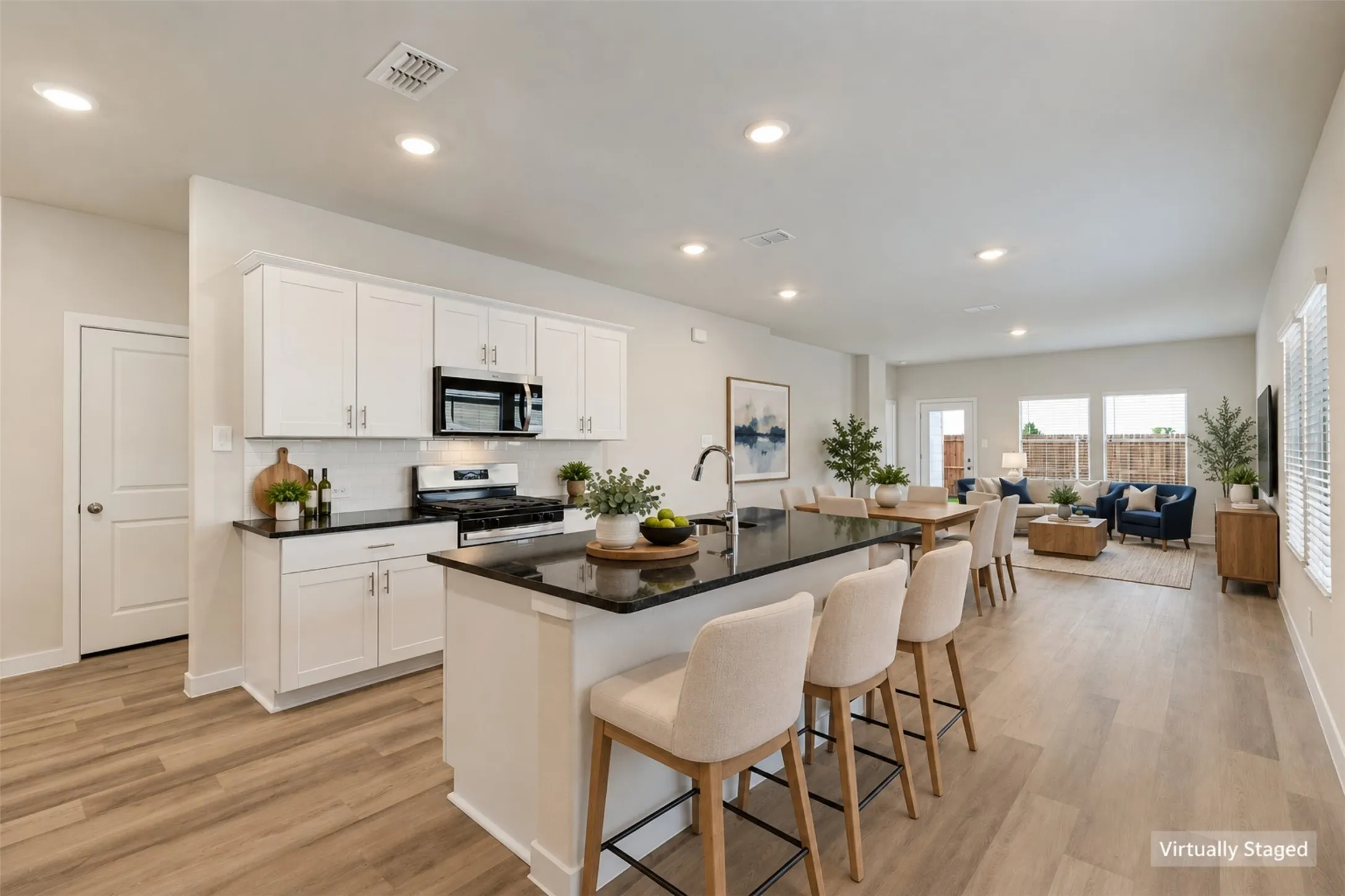 The Heart of the Home! - White shaker-style cabinetry, dark granite countertops, stainless steel appliances, and a spacious island with casual seating make this kitchen a standout! The open design allows you to prepare meals while staying connected to activities in the adjoining living areas.