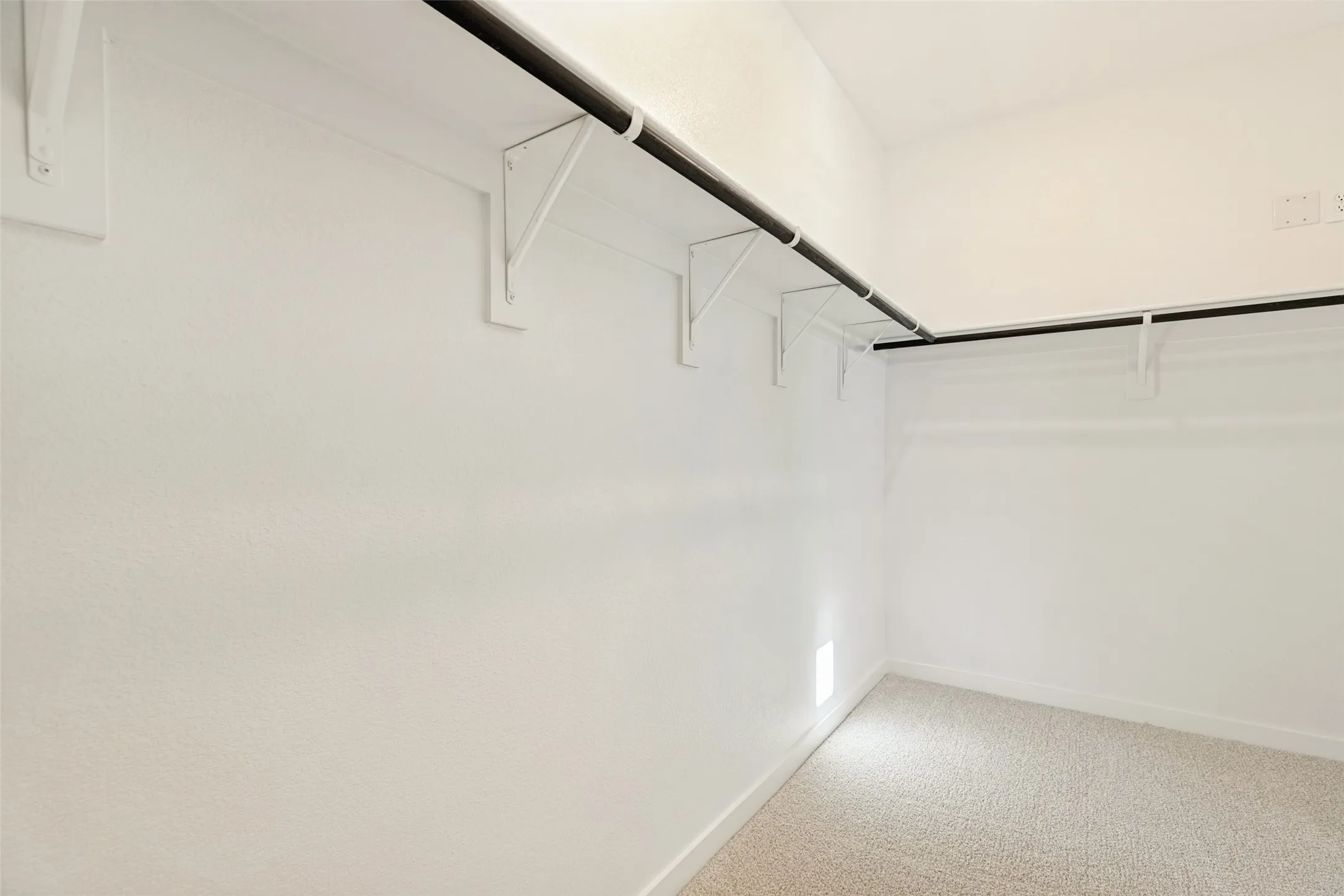 Room for Everything! - The primary suite's spacious walk-in closet features hanging rods and shelving along multiple walls, providing plenty of space to organize clothing, shoes, and accessories while keeping everything within easy reach.