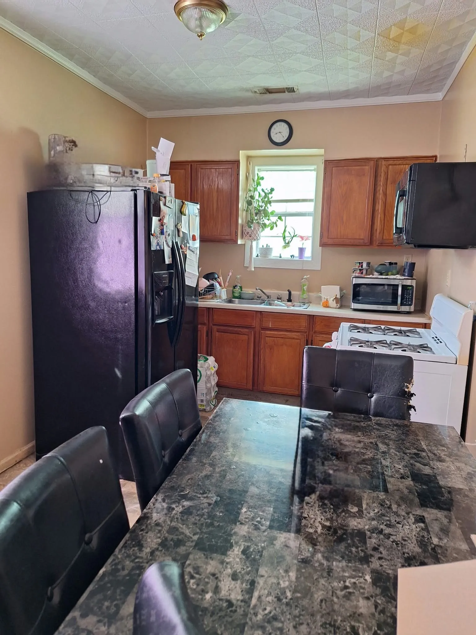 Kitchen with wood-finish cabinetry, built-in microwave, and ceiling-mounted light fixture