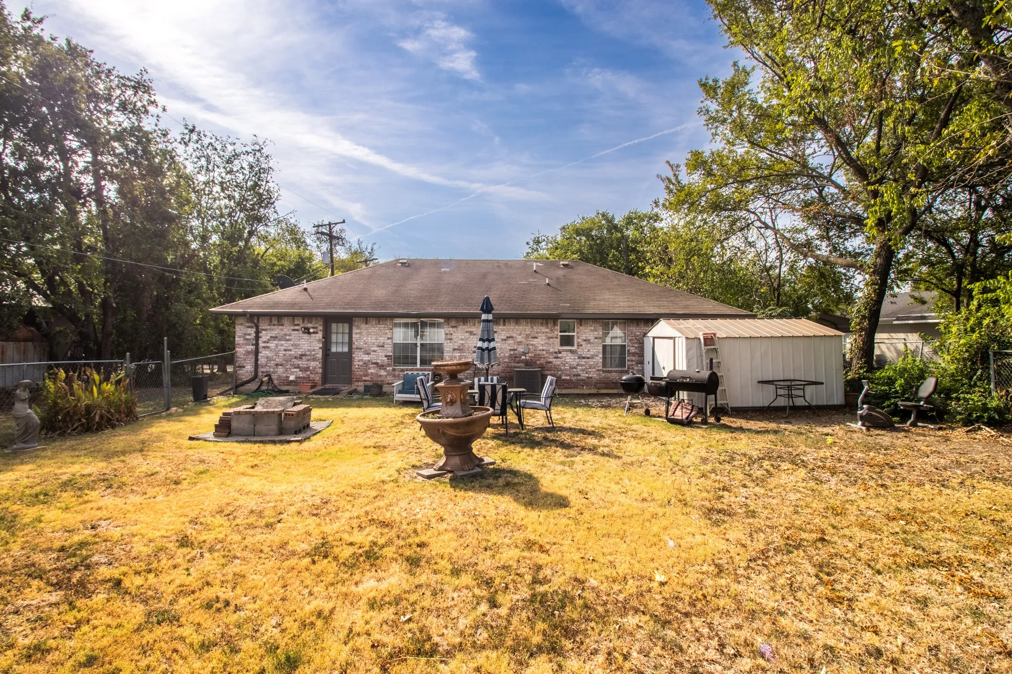 Spacious fenced backyard with storage shed.