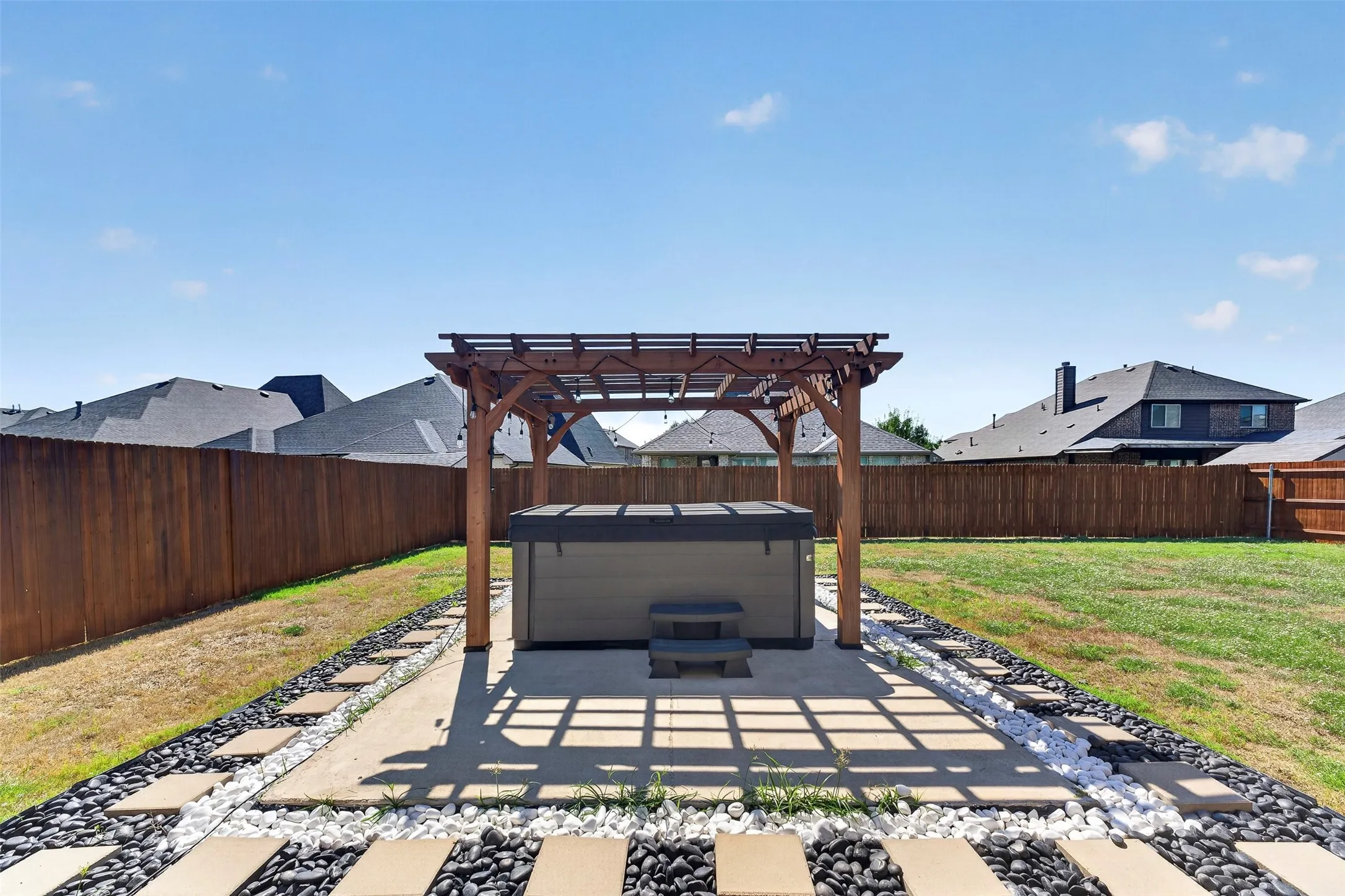 Expansive backyard featuring a wood pergola and privacy fencing