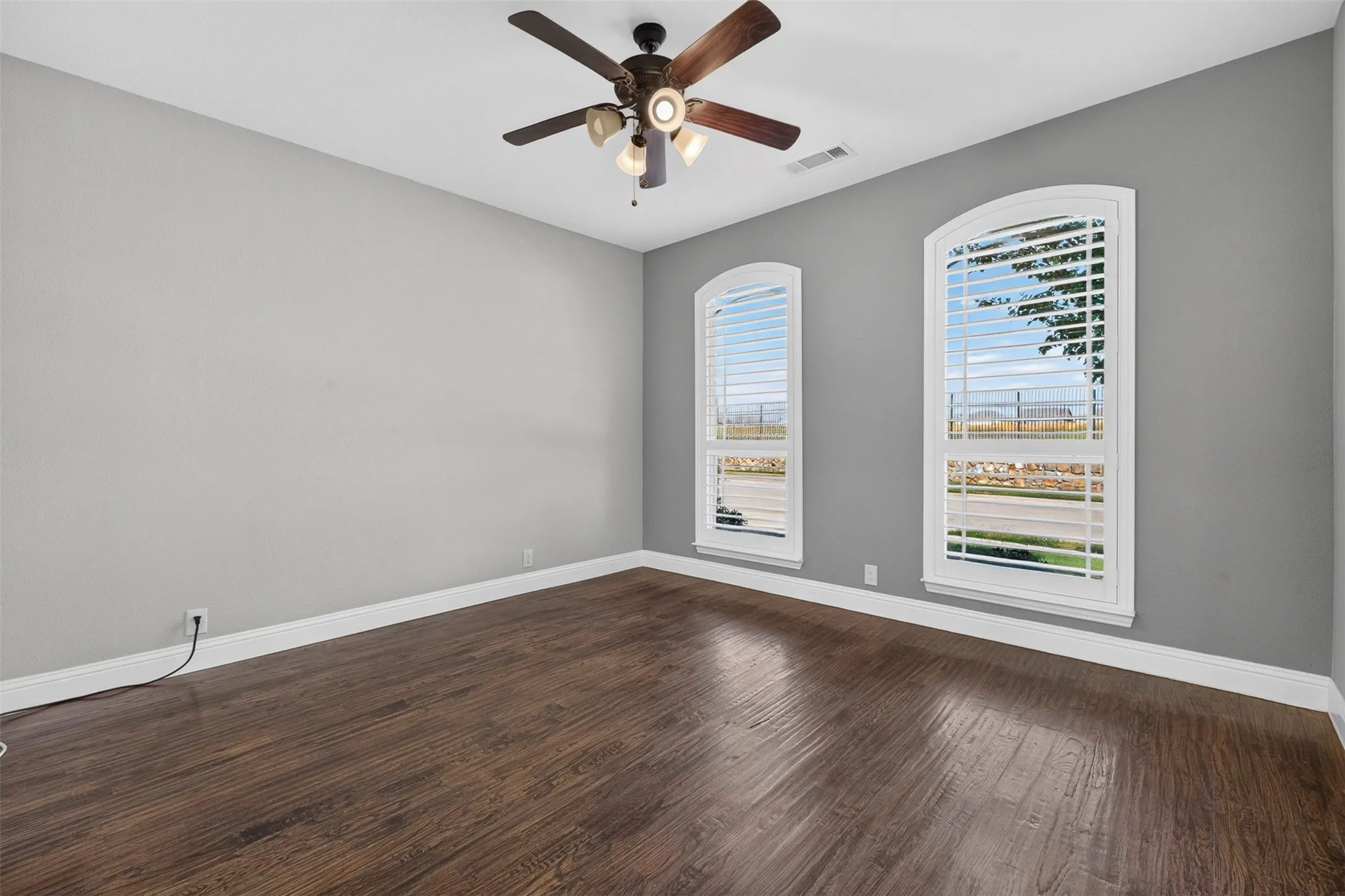 Wood-finish flooring with white baseboards, paired with light gray walls
