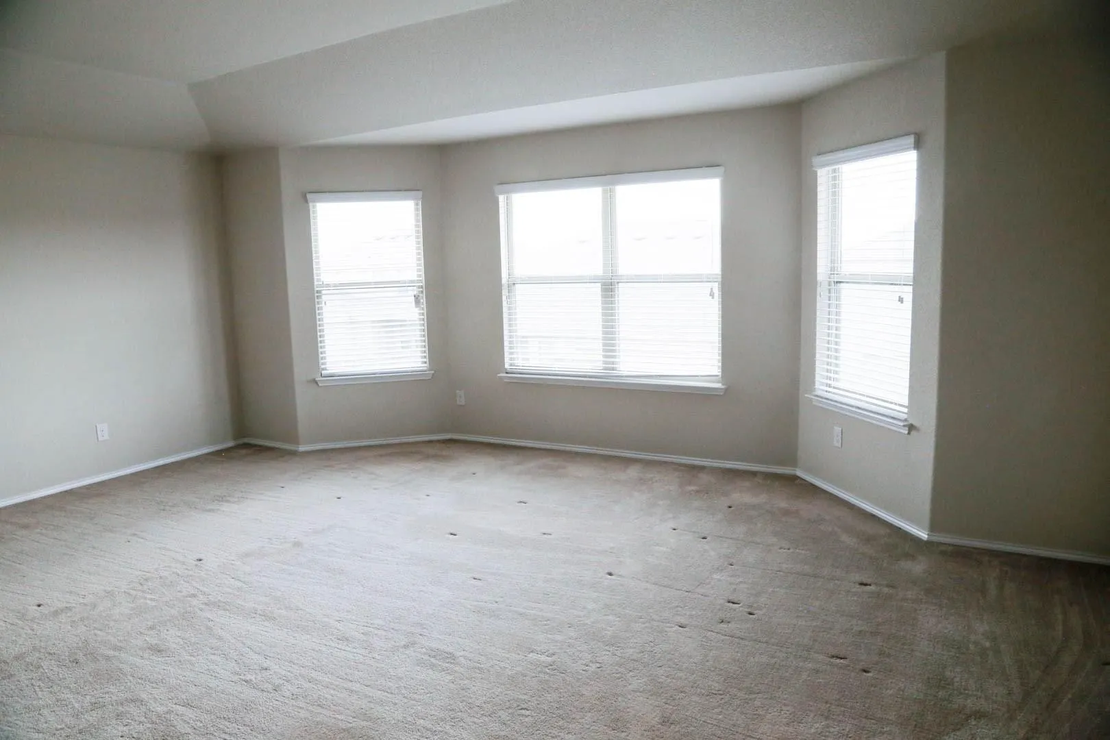 Recessed bay window design with multiple windows and neutral wall tones