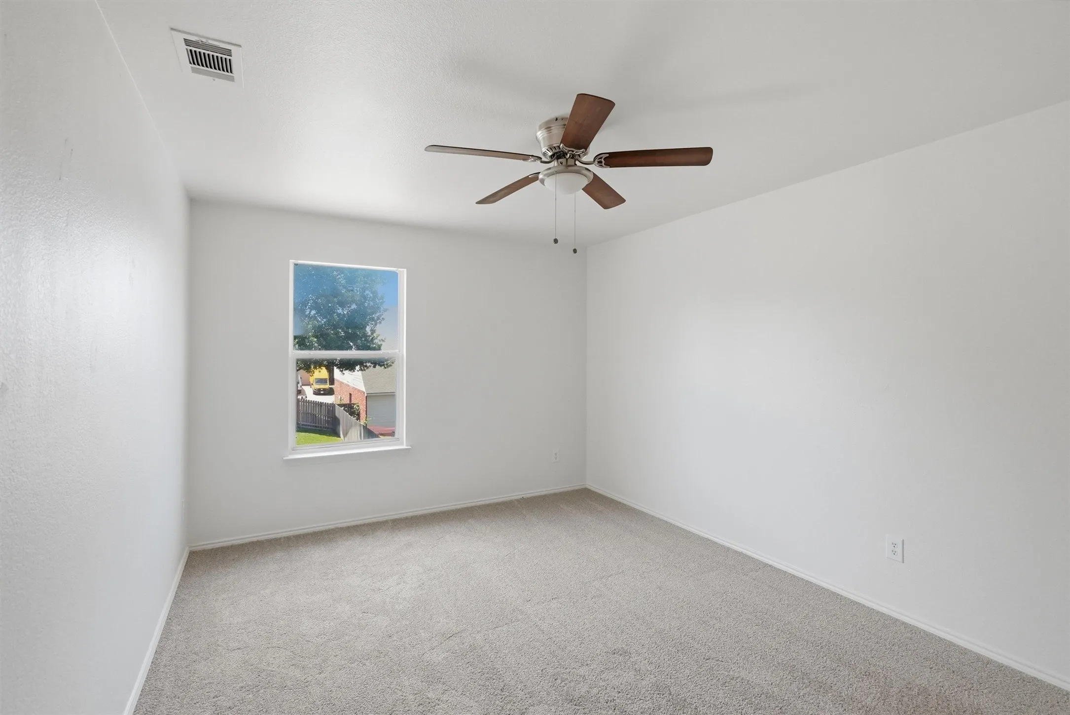 Carpeted flooring, single window, ceiling fan with light fixture, and white wall finishes