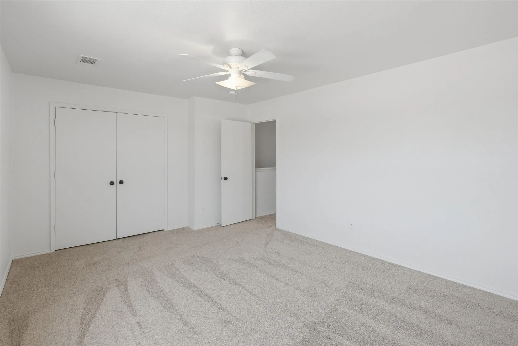 Neutral wall paint with wall-to-wall carpeting, recessed lighting, and a ceiling fan with light fixture
