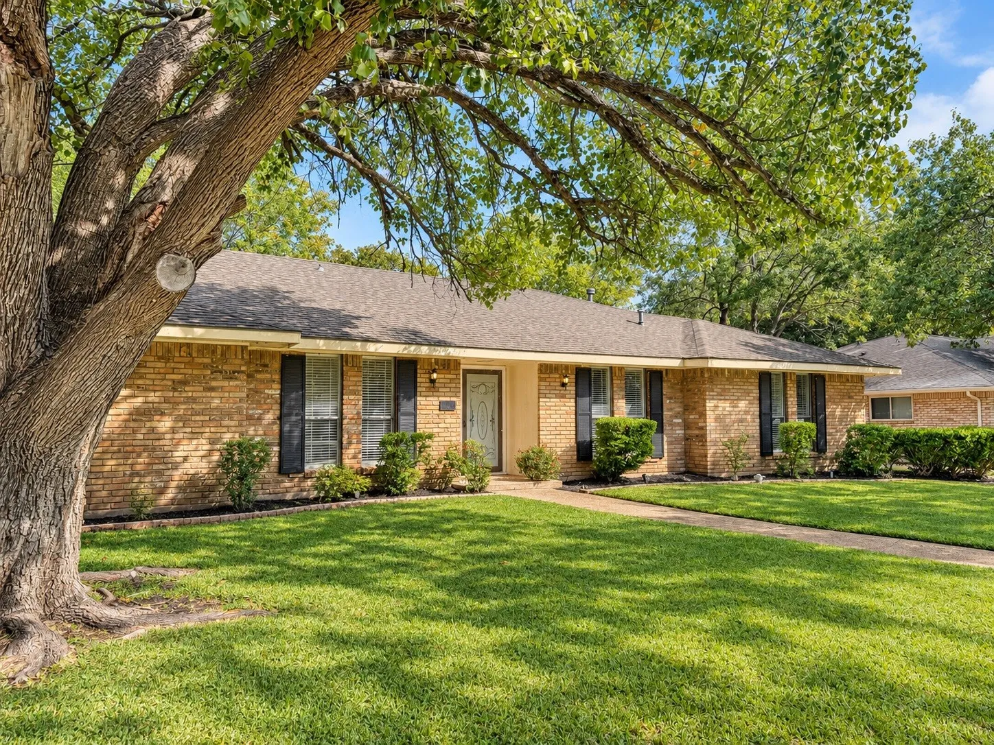 Brick exterior featuring a gabled roof and dark window shutters