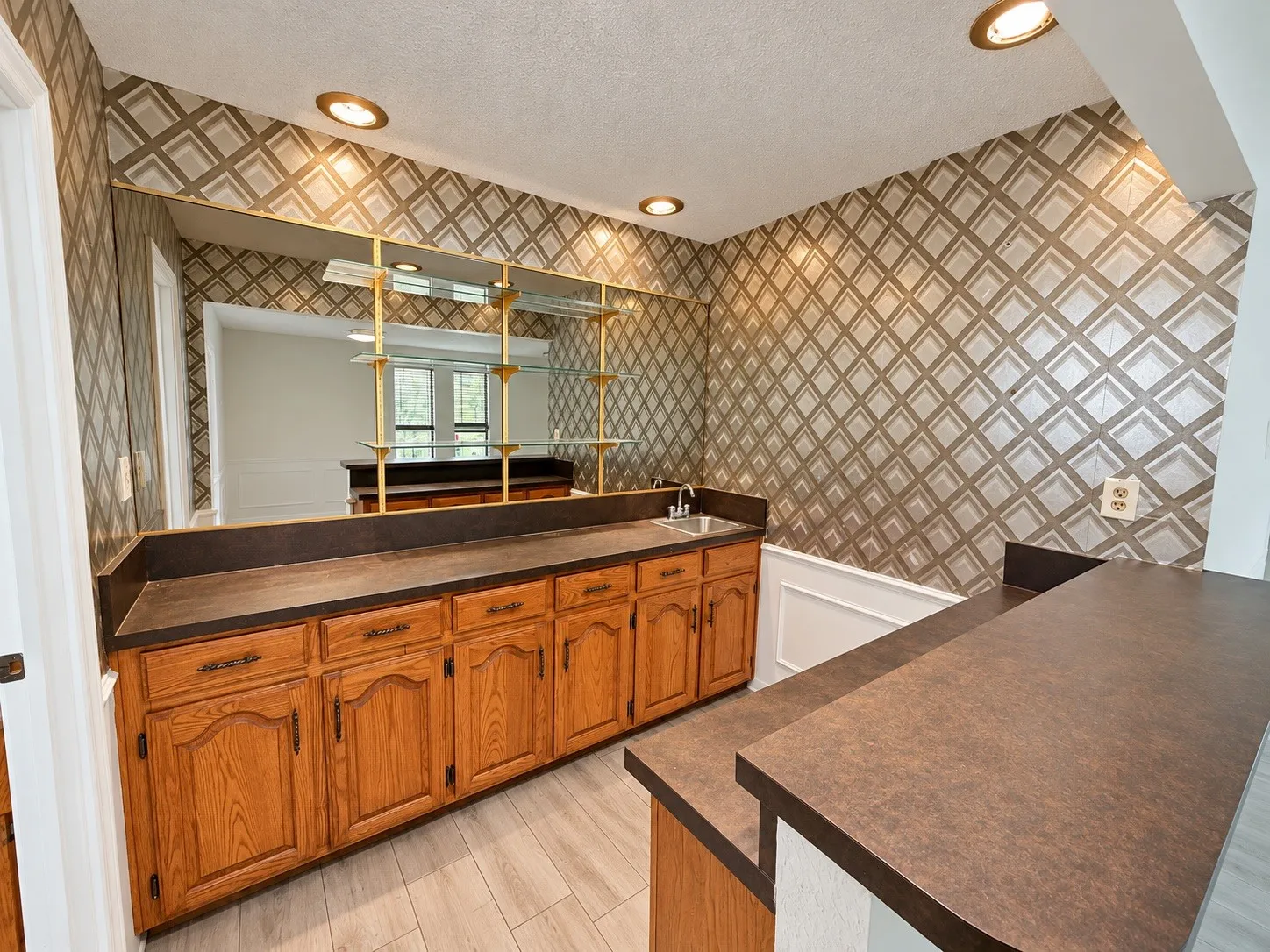 Built-in wet bar featuring wood cabinetry, integrated sink, and an expansive countertop