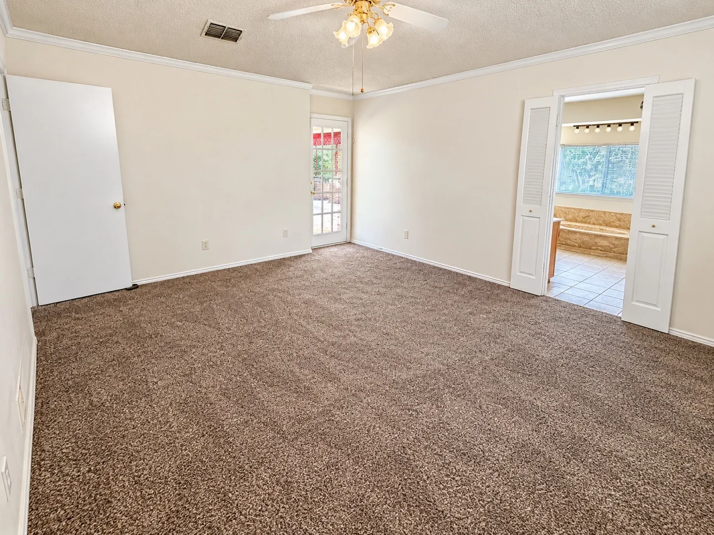 Brown pile carpeting, white walls, and crown molding