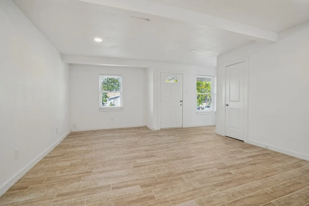 Recessed lighting, wood-finish flooring, white paneled doors, and multiple windows