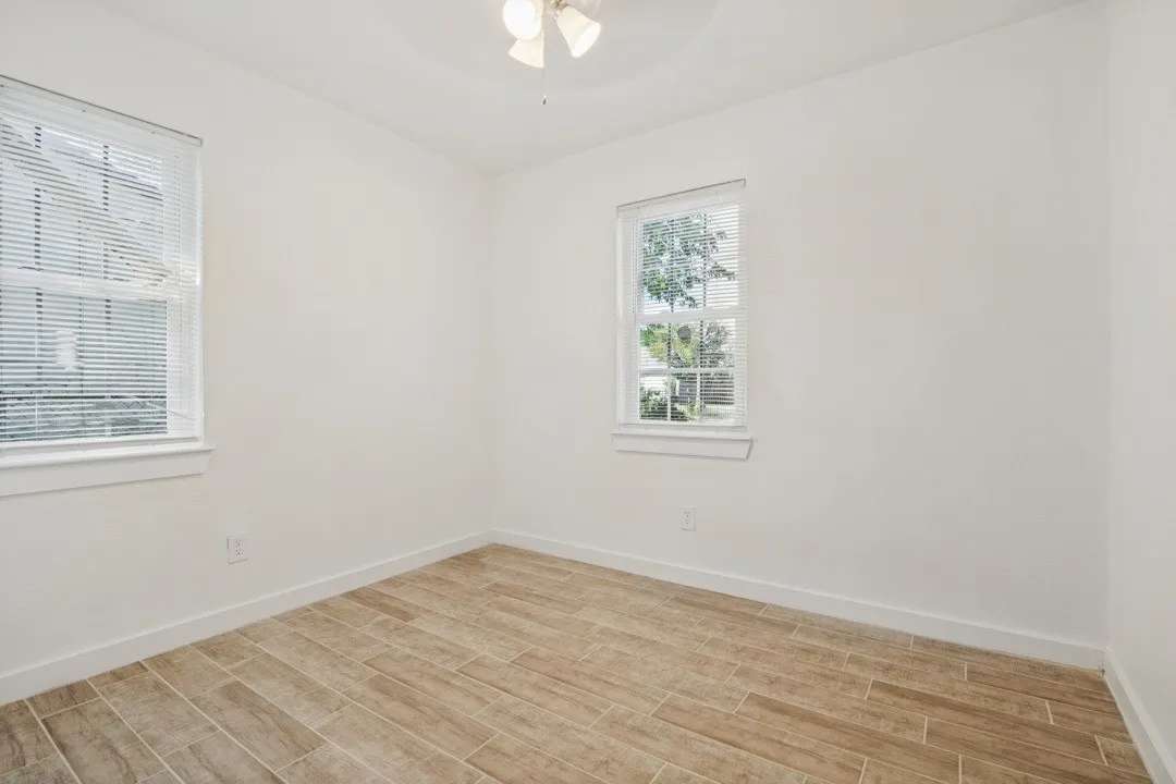 Wood-finish flooring, white walls, and a ceiling-mounted light fixture