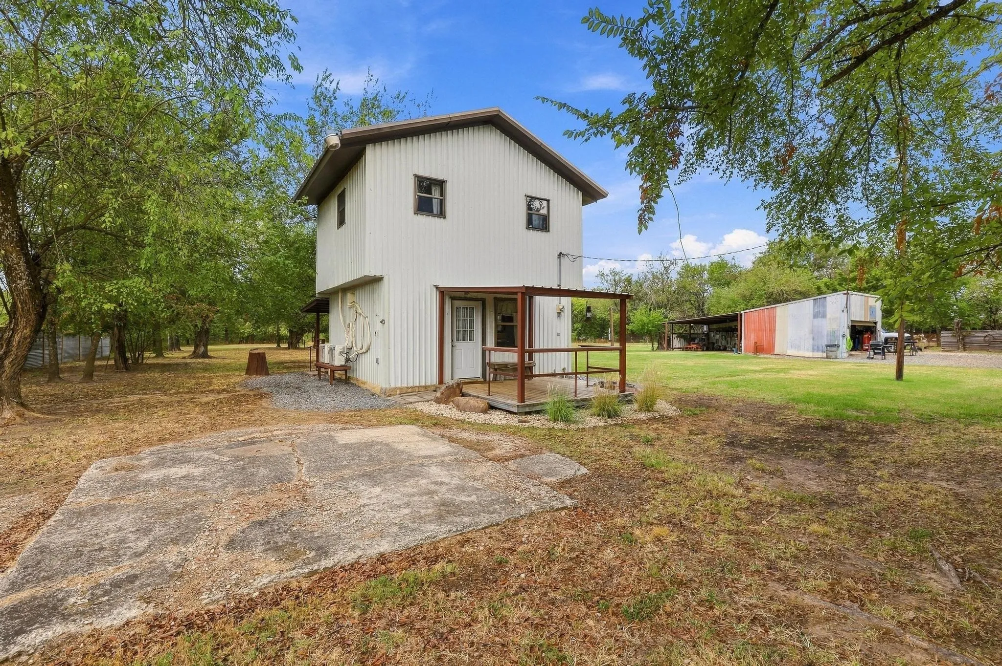 view of house, concrete parking spot & workshop