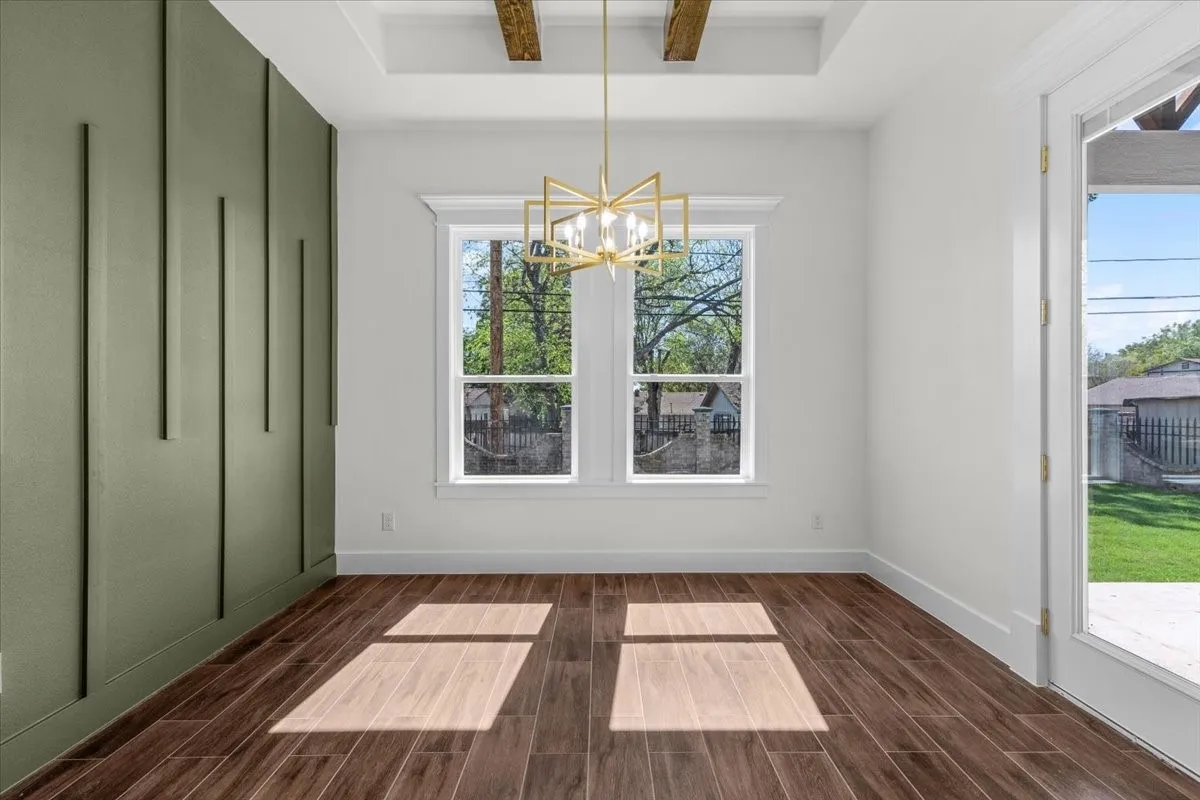 Wood-finish flooring, accent wall with vertical paneling, recessed lighting, exposed ceiling beams, and a modern geometric chandelier