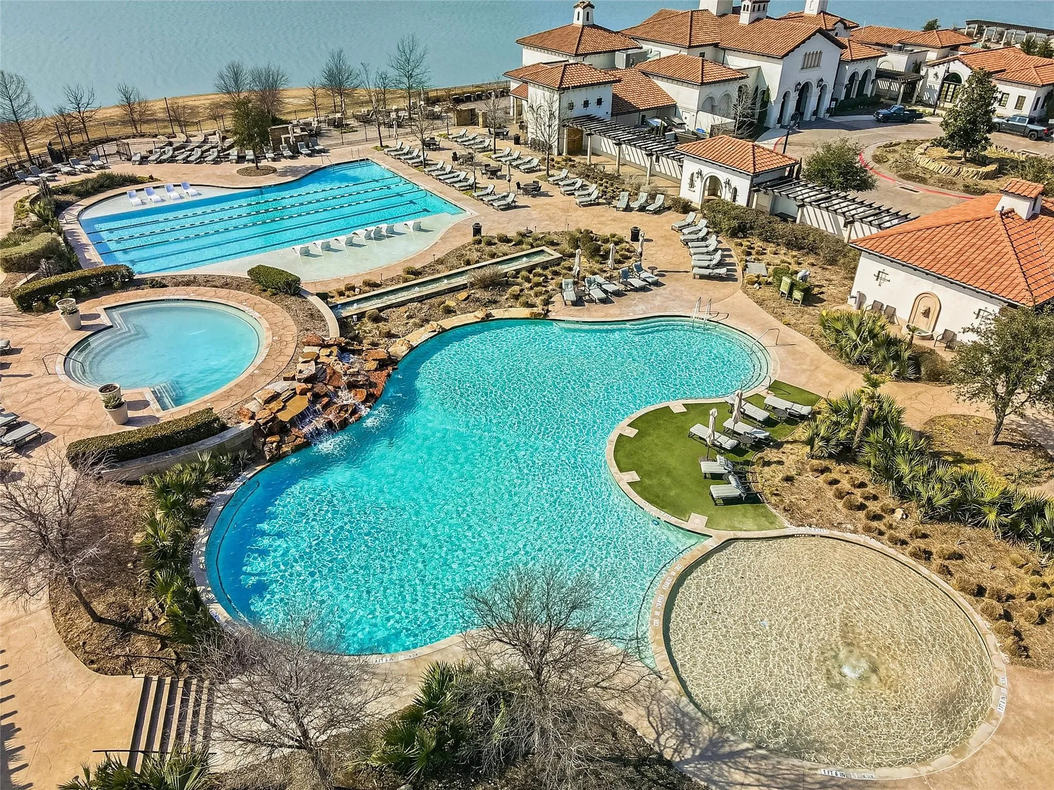 Resort-style amenities featuring multiple pools, a lap pool, a shallow water feature, and a clubhouse with traditional tile roofing