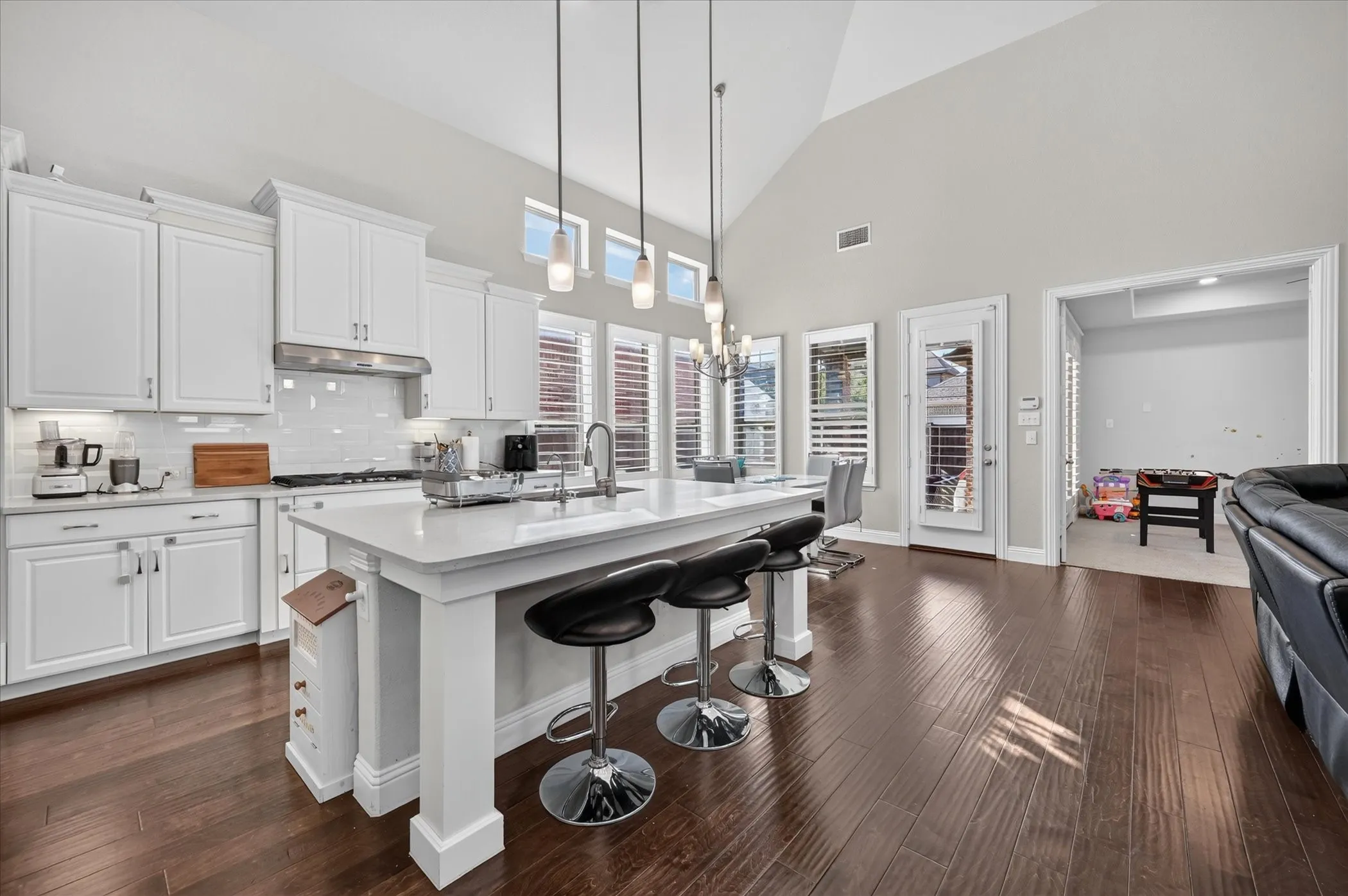 Spacious kitchen featuring white cabinetry, a large center island, and wood-finish flooring