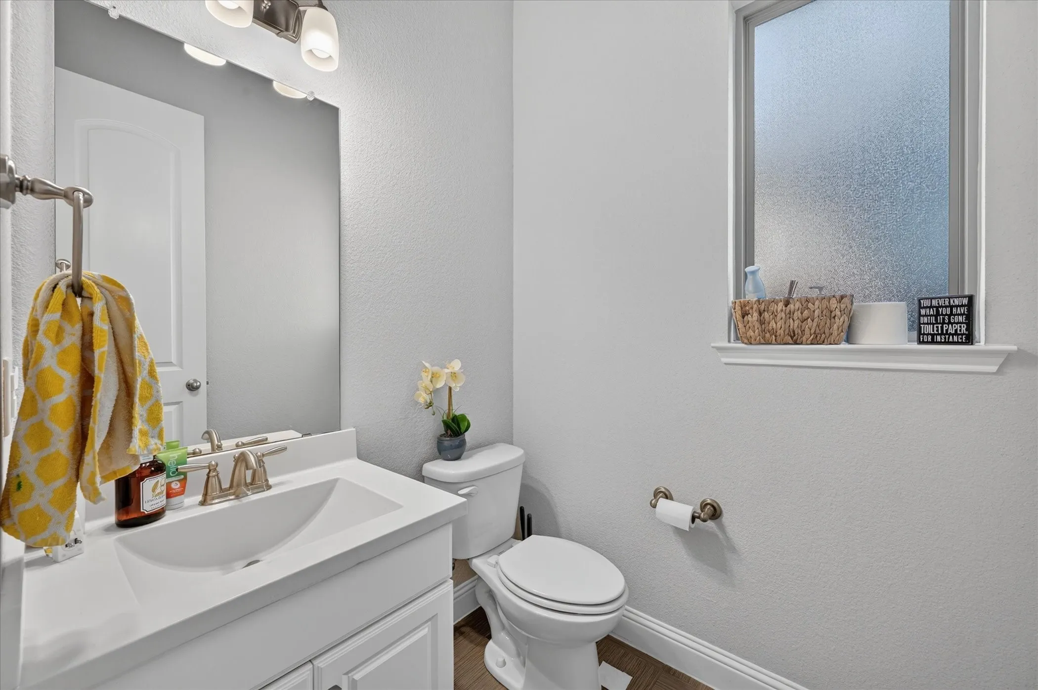 White vanity with an integrated sink and brushed nickel faucet
