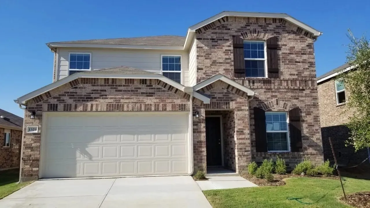 Brick and siding exterior with dark shutters, attached two-car garage, and landscaped front yard