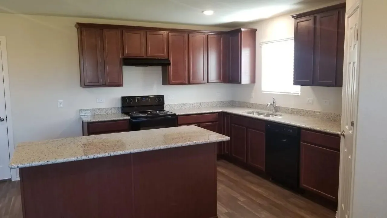Kitchen featuring dark wood-finish cabinetry, light-toned countertops, a black range, and a black dishwasher