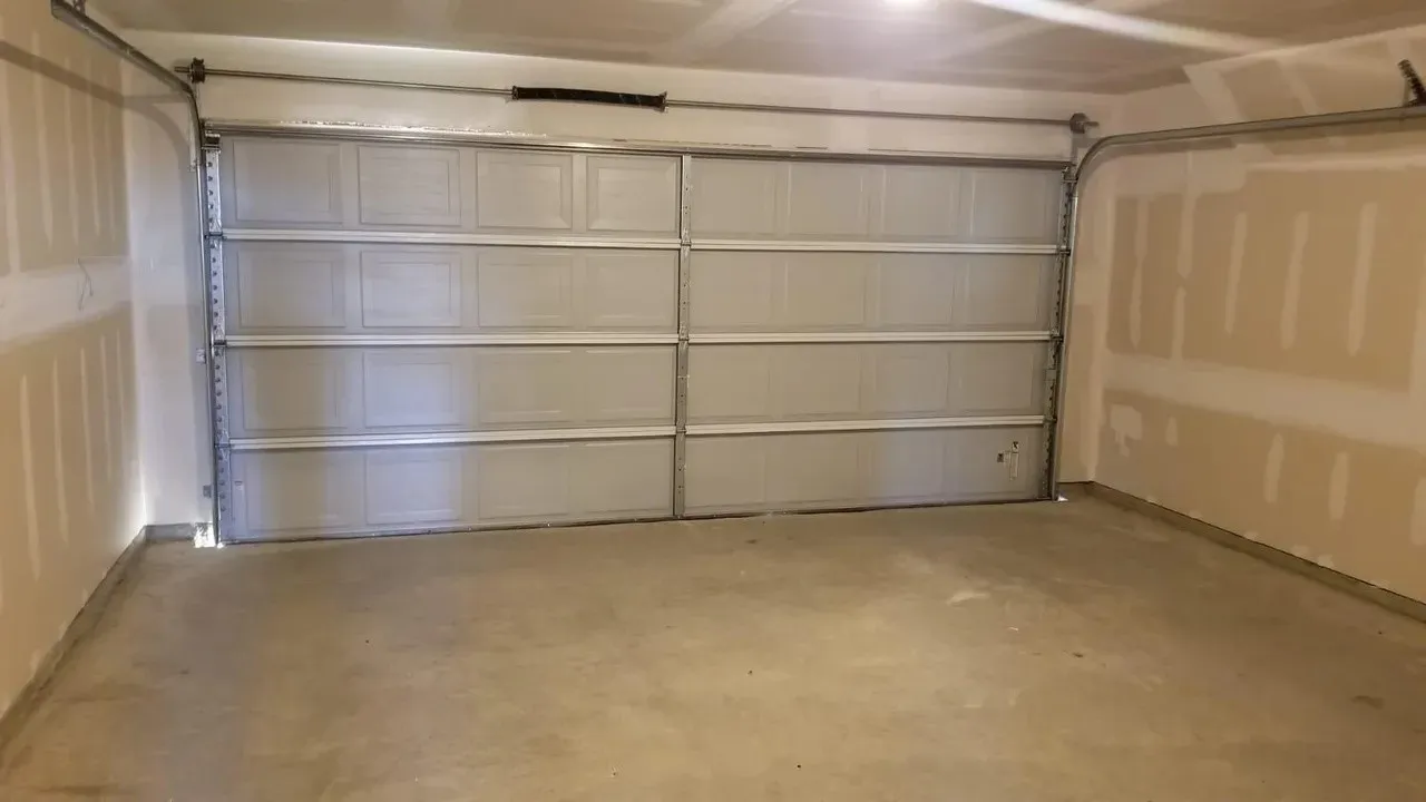 Spacious garage with a sectional overhead door and concrete flooring