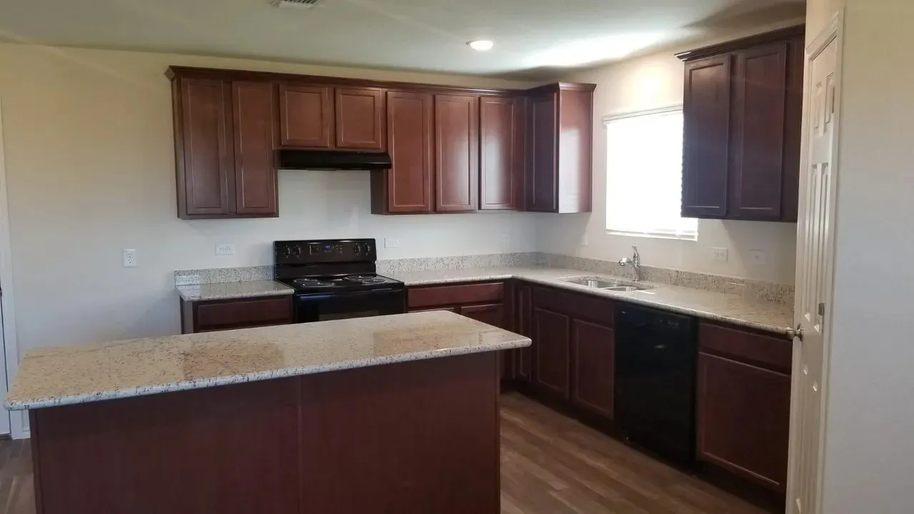 Kitchen featuring dark wood cabinetry, light-toned countertops, wood-finish flooring, a black range, and a black dishwasher
