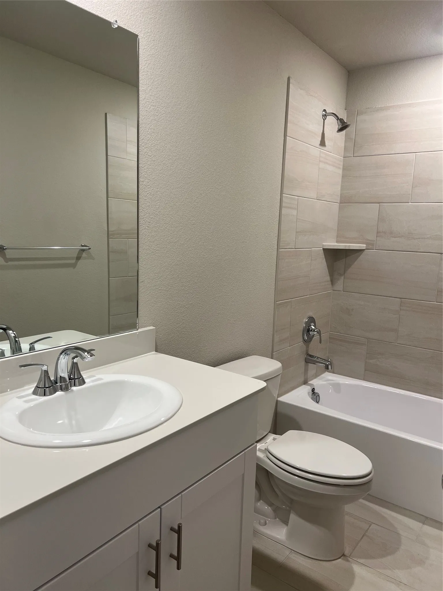 Vanity with integrated sink, chrome faucet, wall-mounted mirror, and cabinet storage