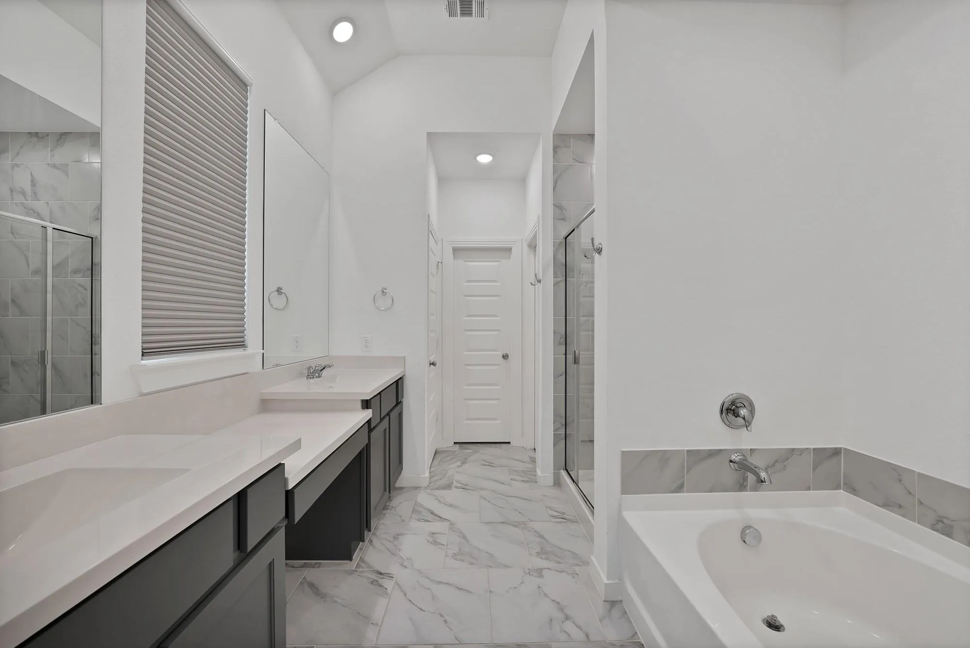 Dual vanities with integrated sinks and light-colored countertops