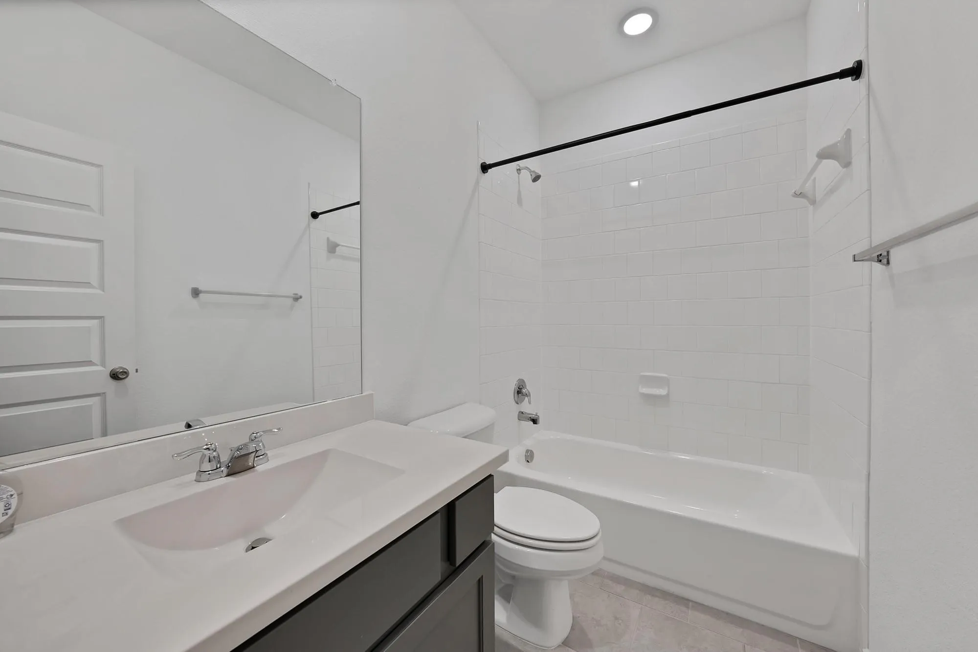 Modern bathroom featuring a single vanity with an integrated sink, polished chrome faucet, and dark wood-finish cabinetry