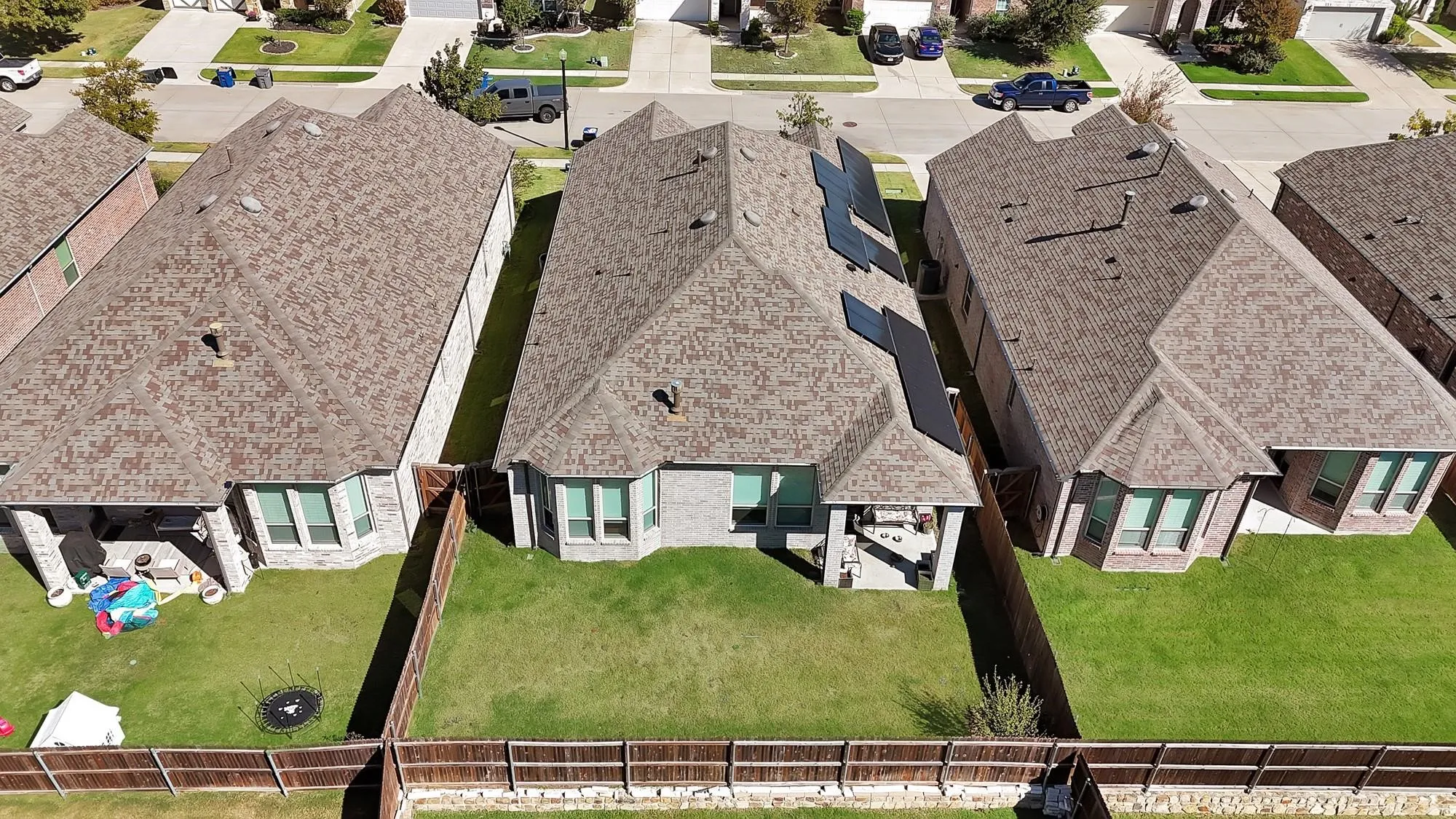 Rear exterior featuring a covered patio, fenced backyard, and bay windows