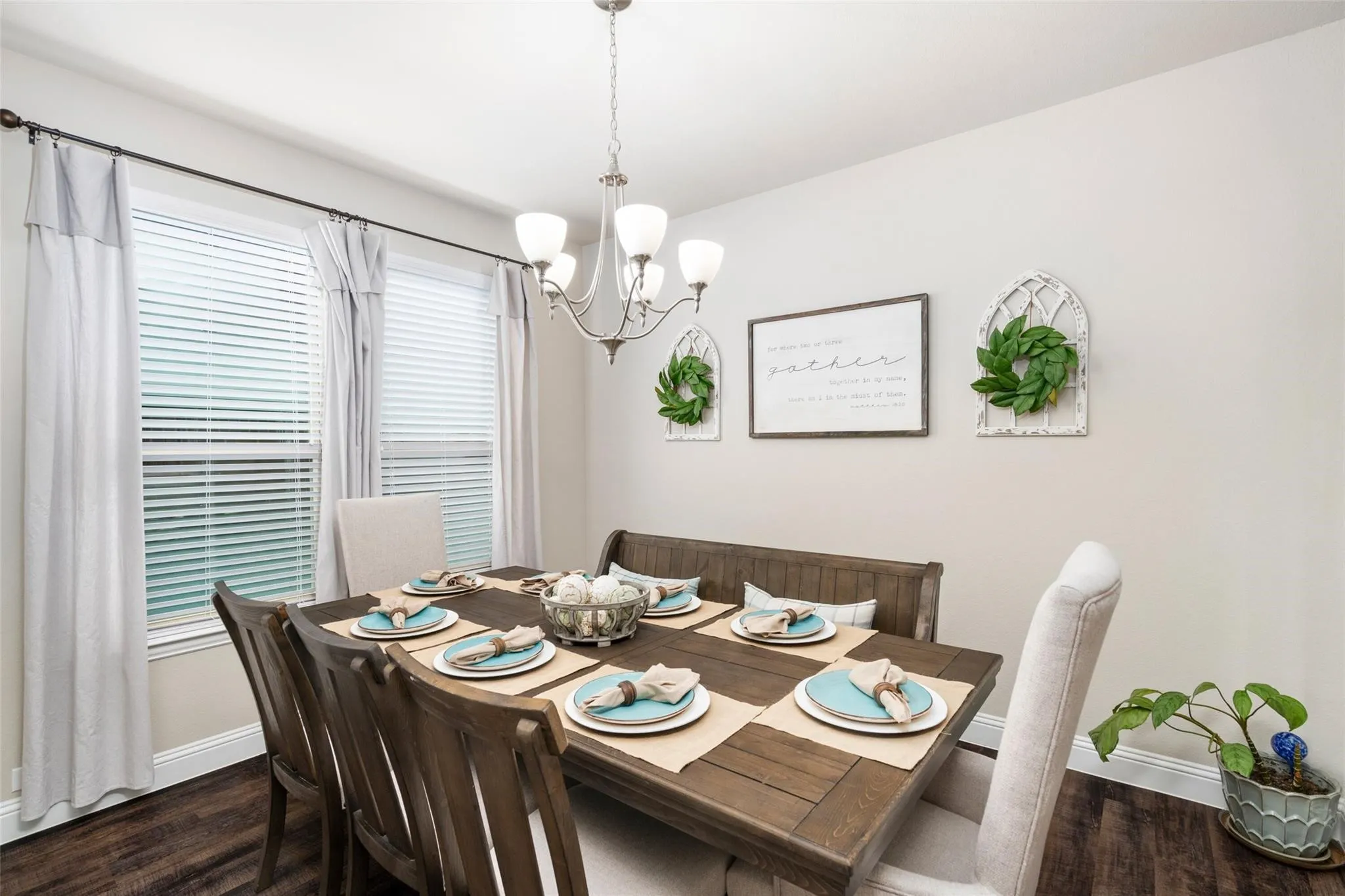 Recessed dining area with a chandelier and two windows featuring blinds