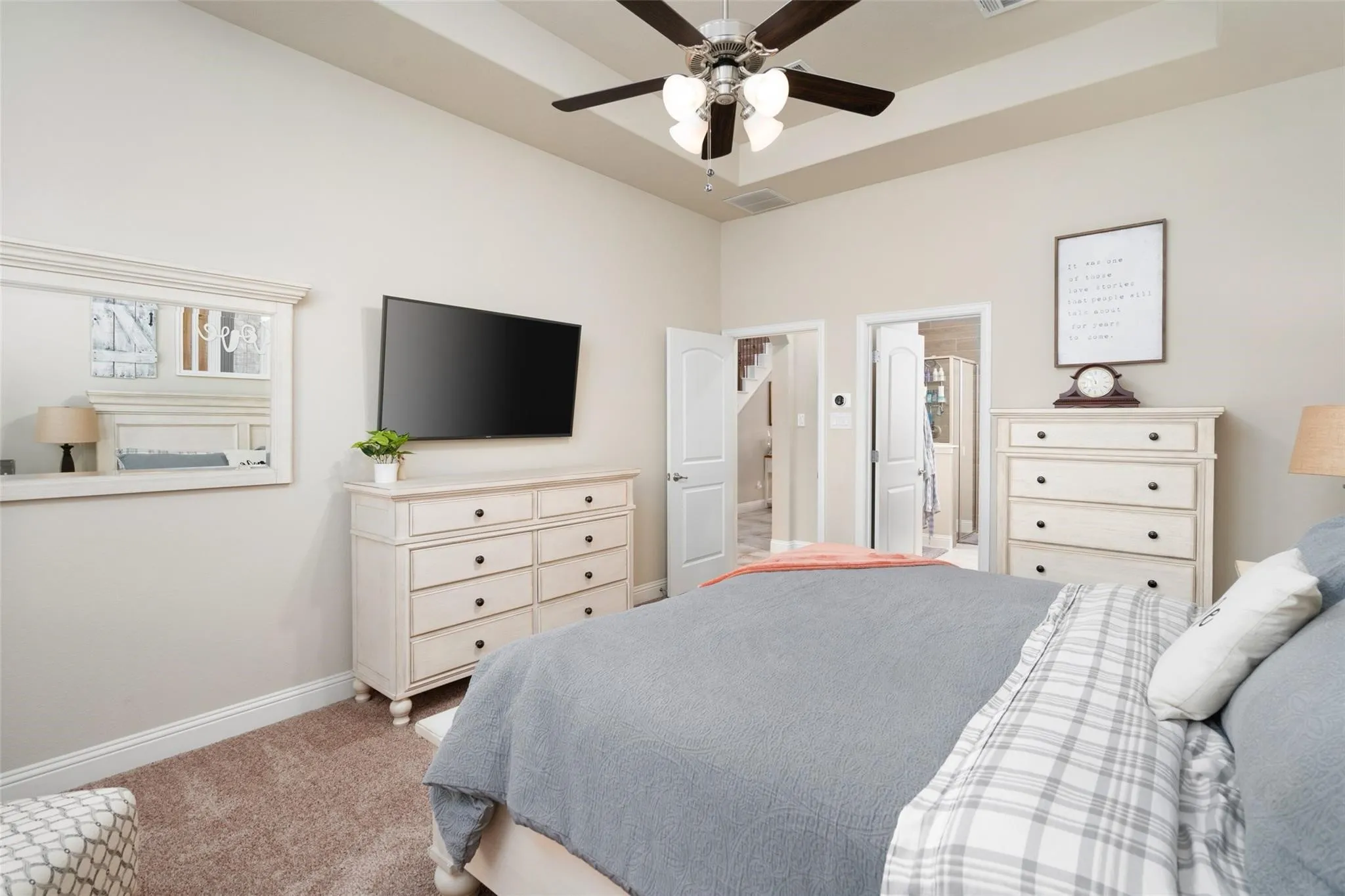 Recessed ceiling with an overhead fan light fixture, light-toned wall paint, and plush carpet flooring