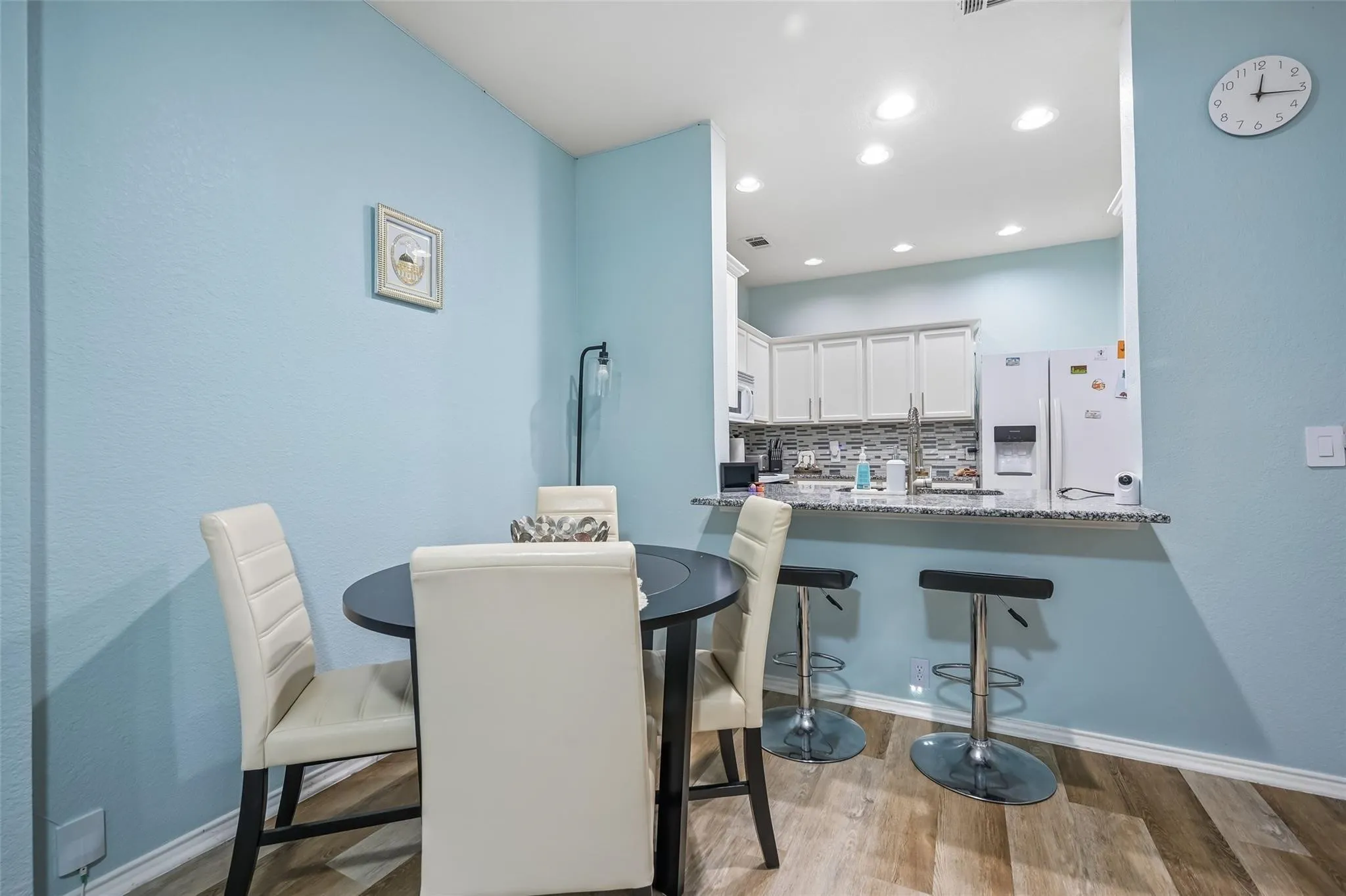 Kitchen pass-through with a stone countertop and recessed lighting