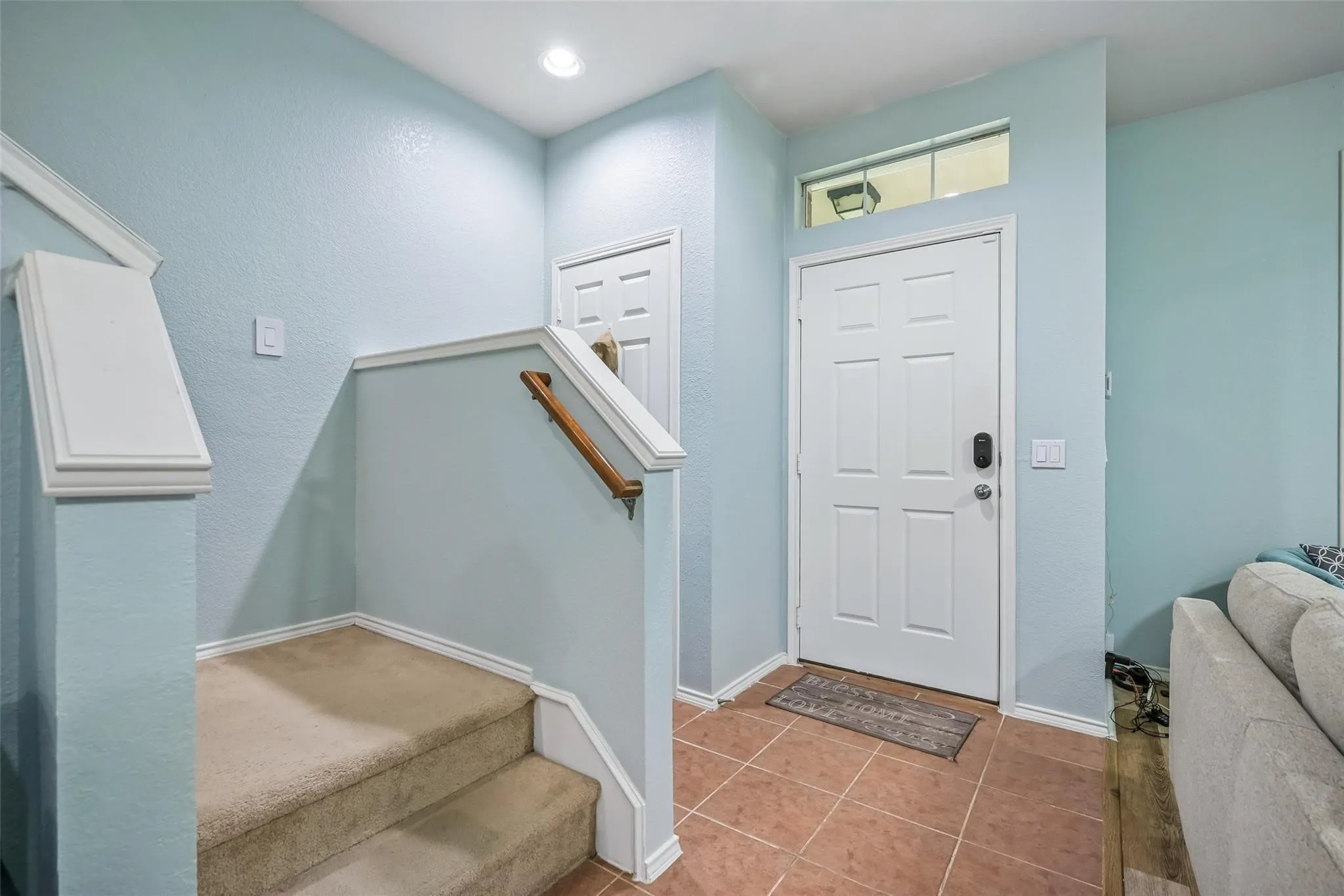 Entryway featuring a paneled door, transom window, recessed lighting, and tile flooring